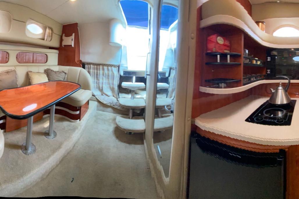 Interior of 2003 Rinker Fiesta Vee 342 boat with dining area and kitchenette.