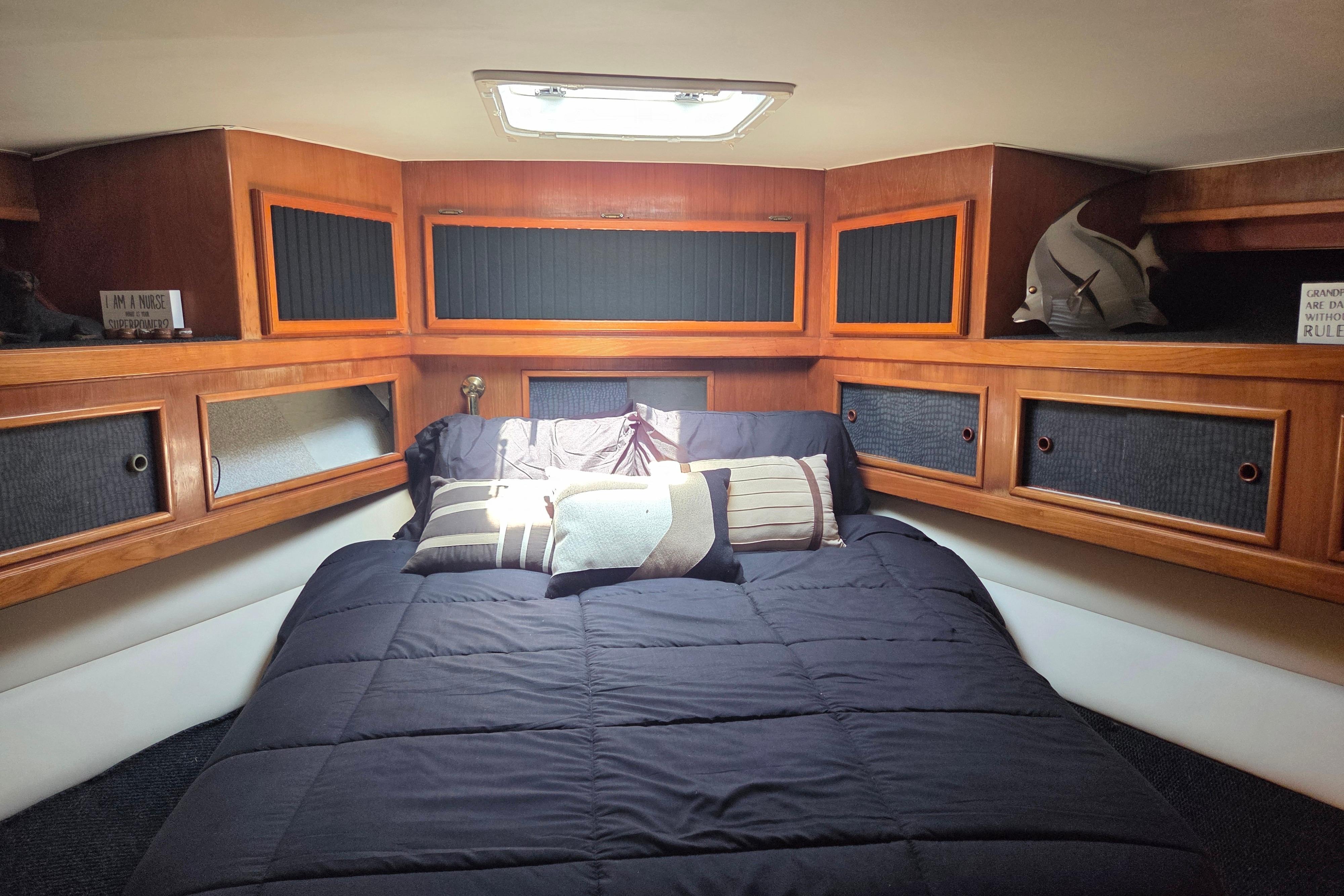 Cozy cabin interior of 1990 Egg Harbor Golden Egg 42 yacht with wood paneling and bedding.