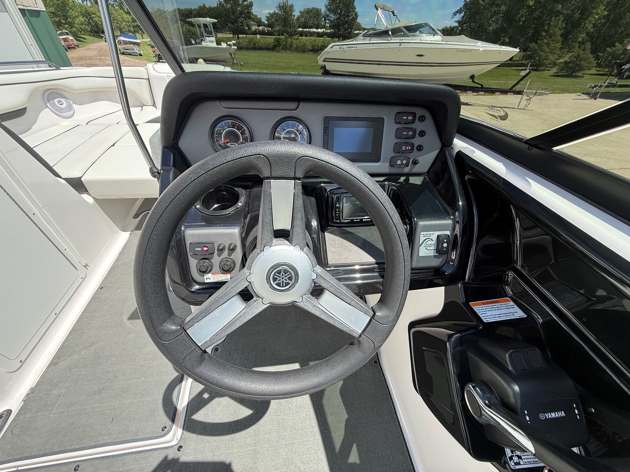 The cockpit of a Yamaha SX210 boat with steering wheel and dashboard.