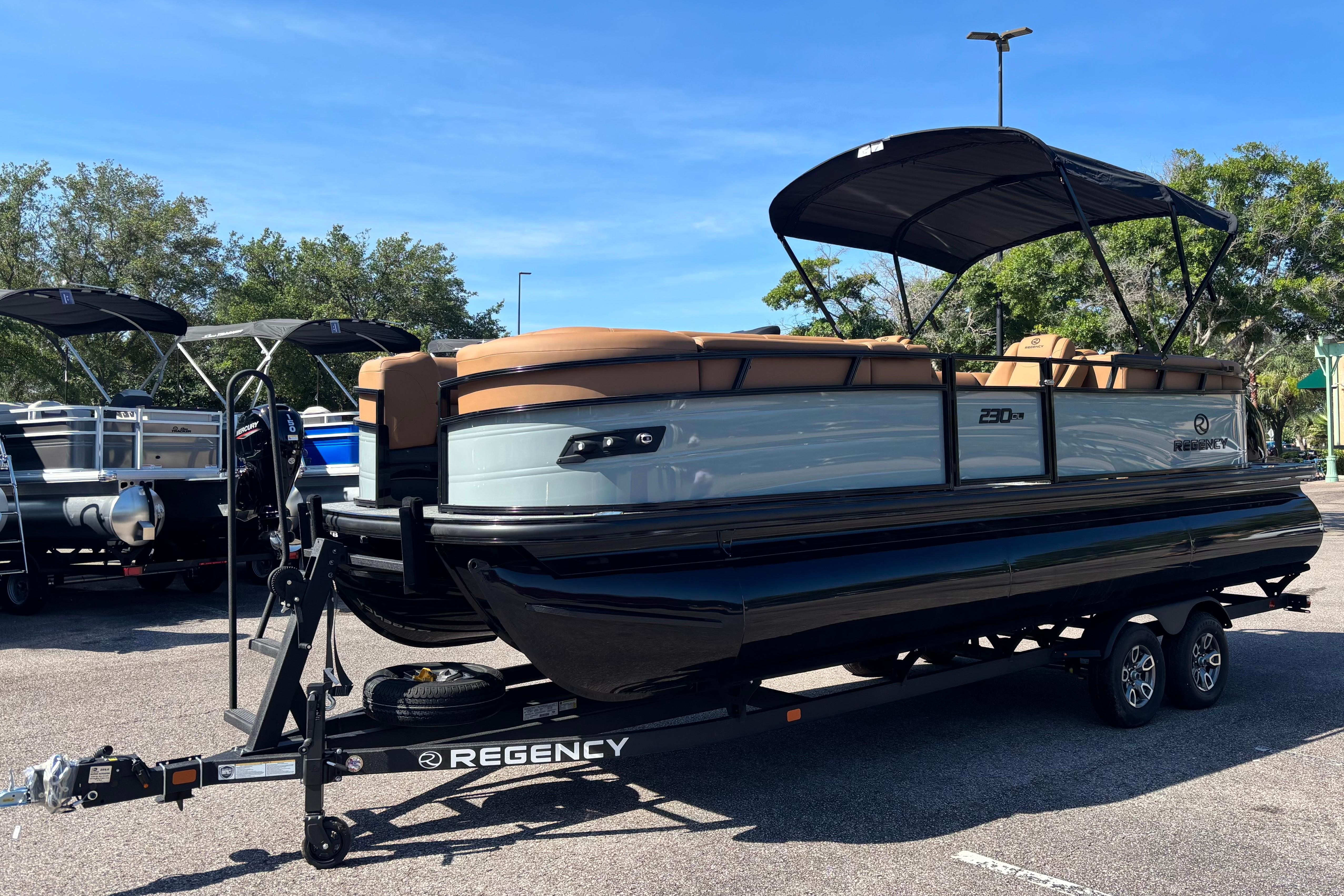 2026 Regency 230 DL pontoon boat on trailer in parking lot.