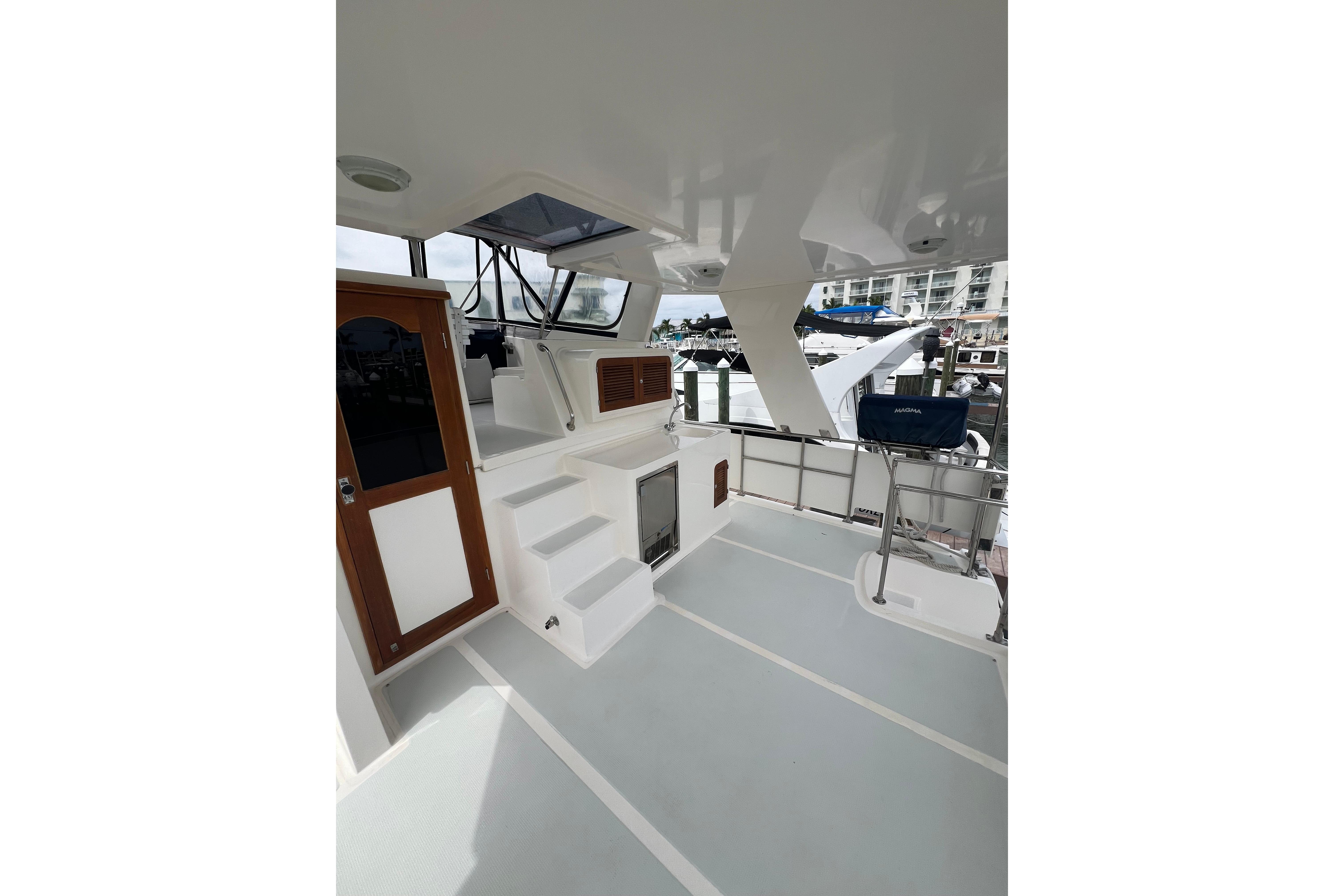2007 Heritage East 36 Sundeck Trawler, spacious deck with steps and wooden door.