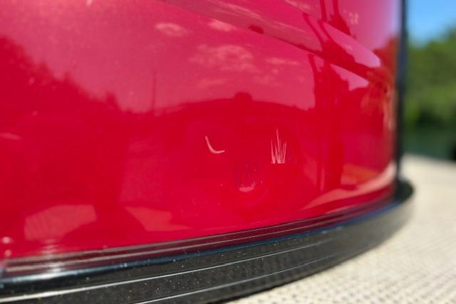 Close-up of a red 2025 Regency 250 DL3 boat with visible scratches.