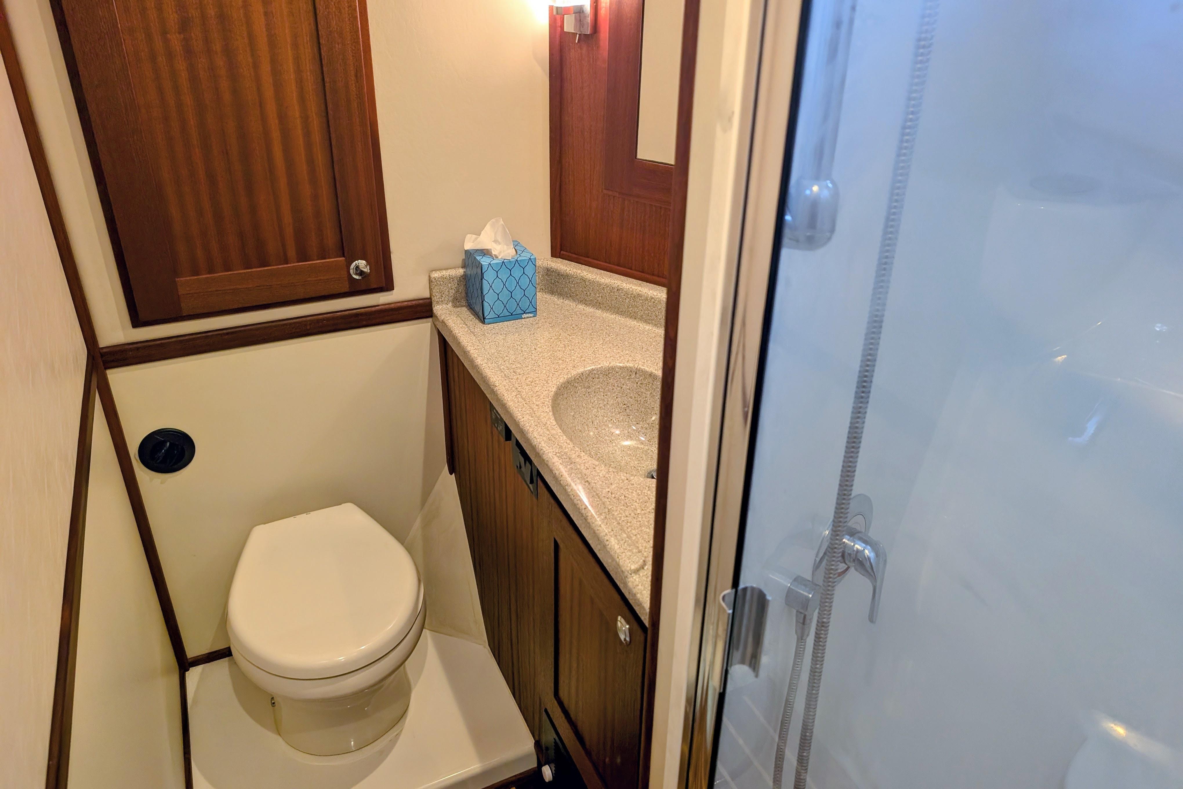 Bathroom interior of 2015 American Tug 435 with shower, toilet, and sink.