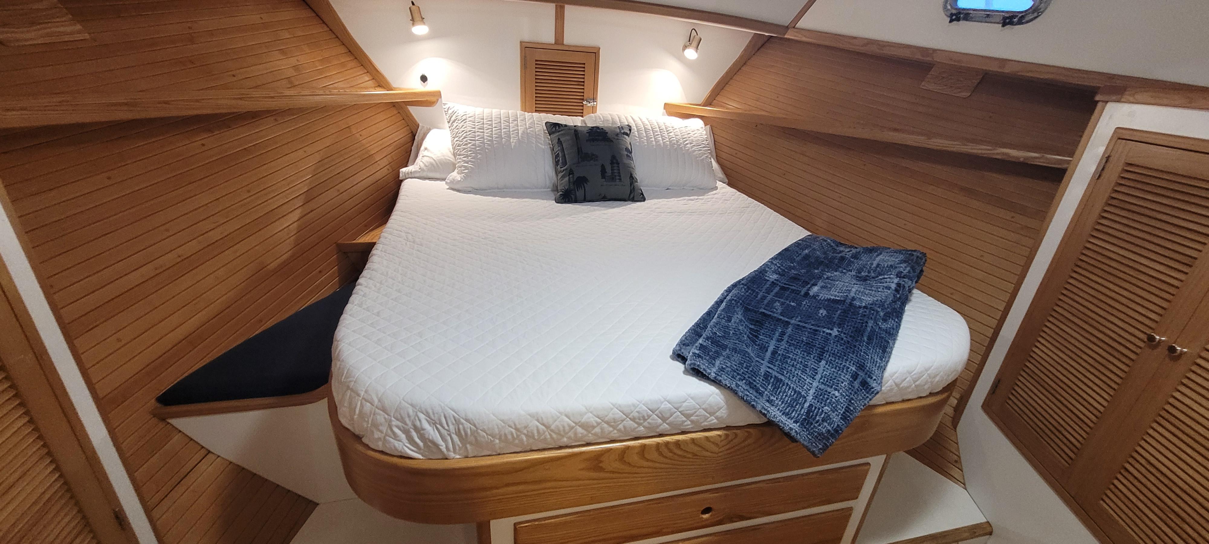 Cozy cabin interior of 1989 Duffy Wilbur 42 Flybridge Cruiser with wooden accents and comfortable bedding.