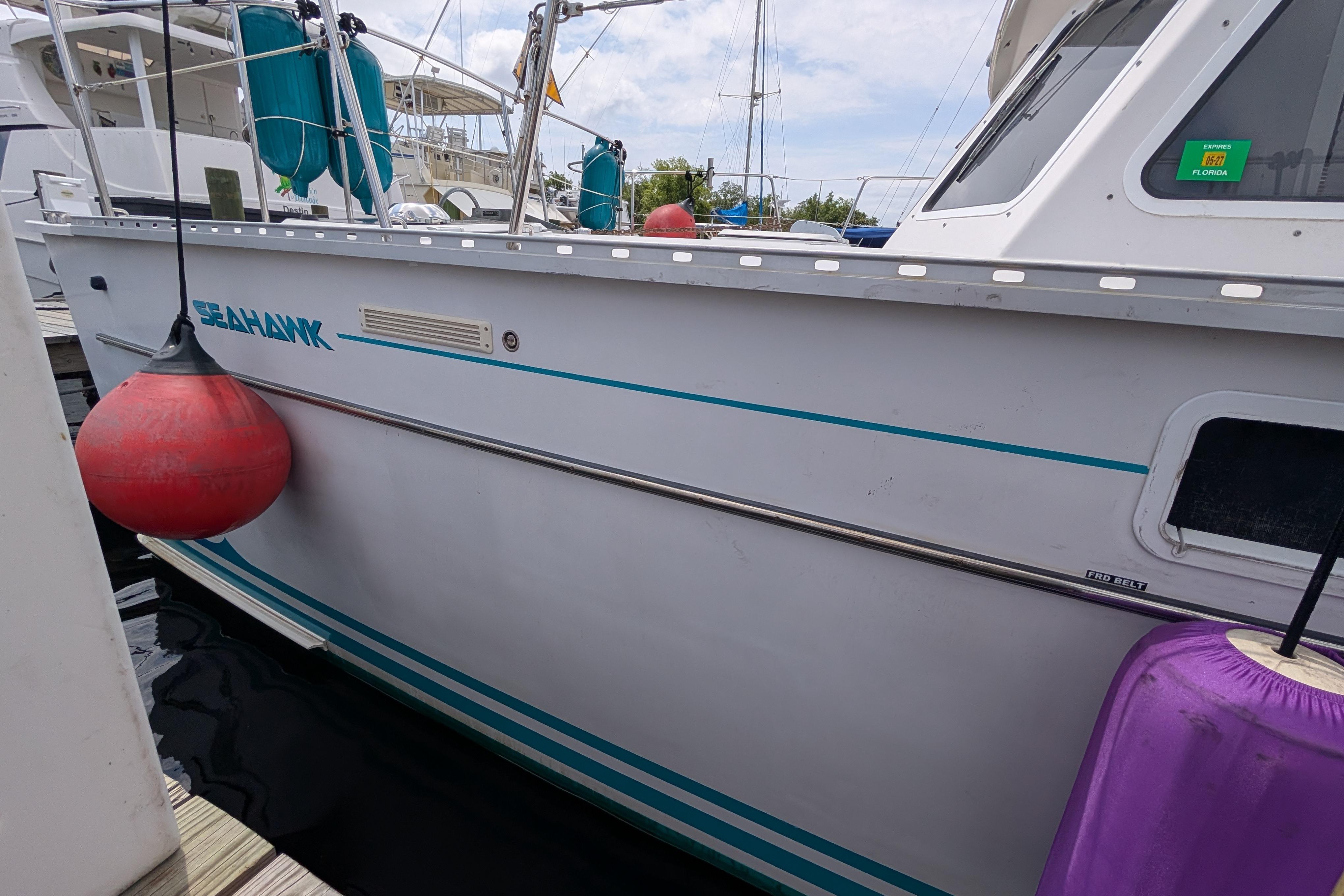 2004 PDQ 34 Powercat docked, featuring "SEAHANK" name and colorful fenders.