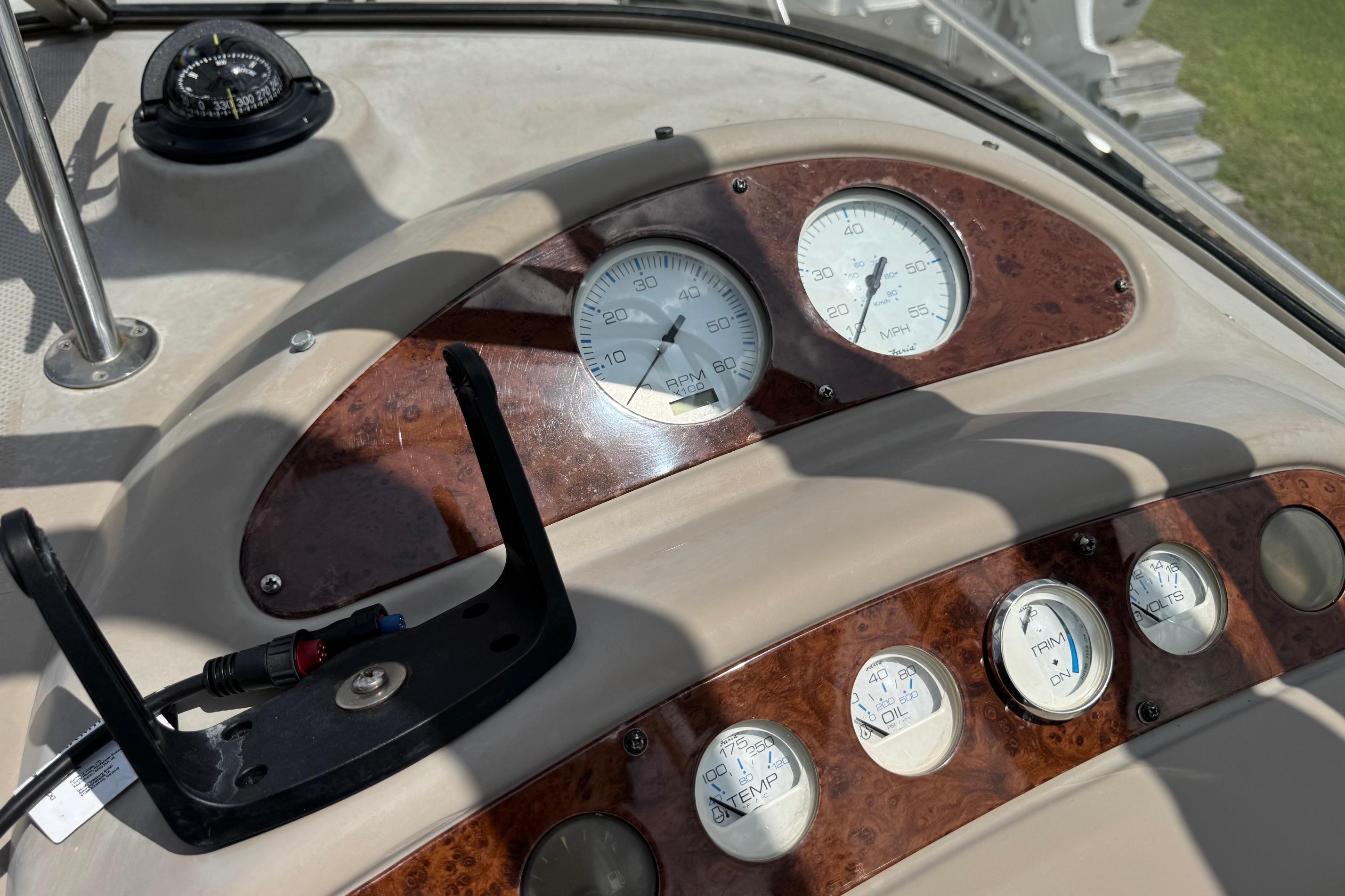 Dashboard of a 2000 Maxum 2400 SCR boat with gauges and compass.