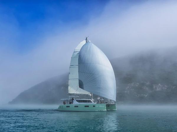 Sailboat Vision 444 ES 2026 navigating through misty waters with large white sail.