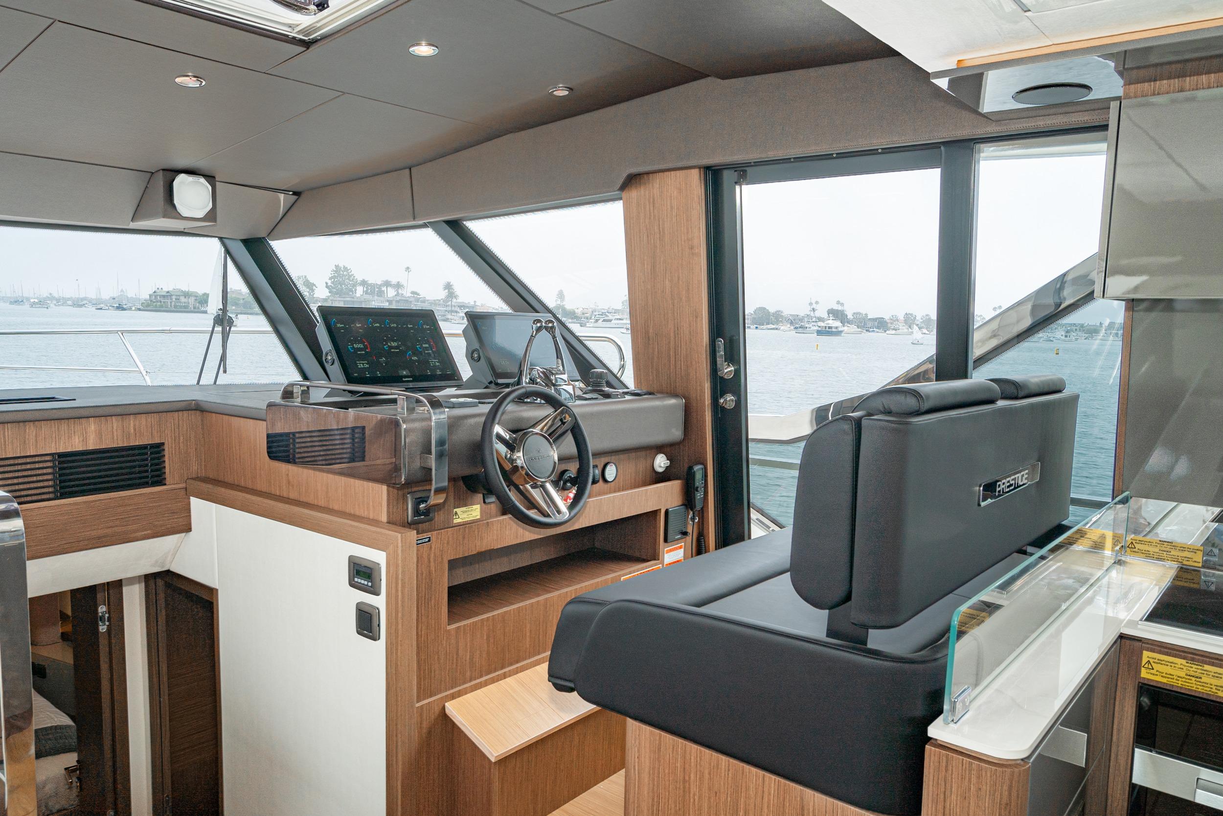 2024 Prestige X60 yacht interior with modern helm, luxurious seating, and panoramic windows.
