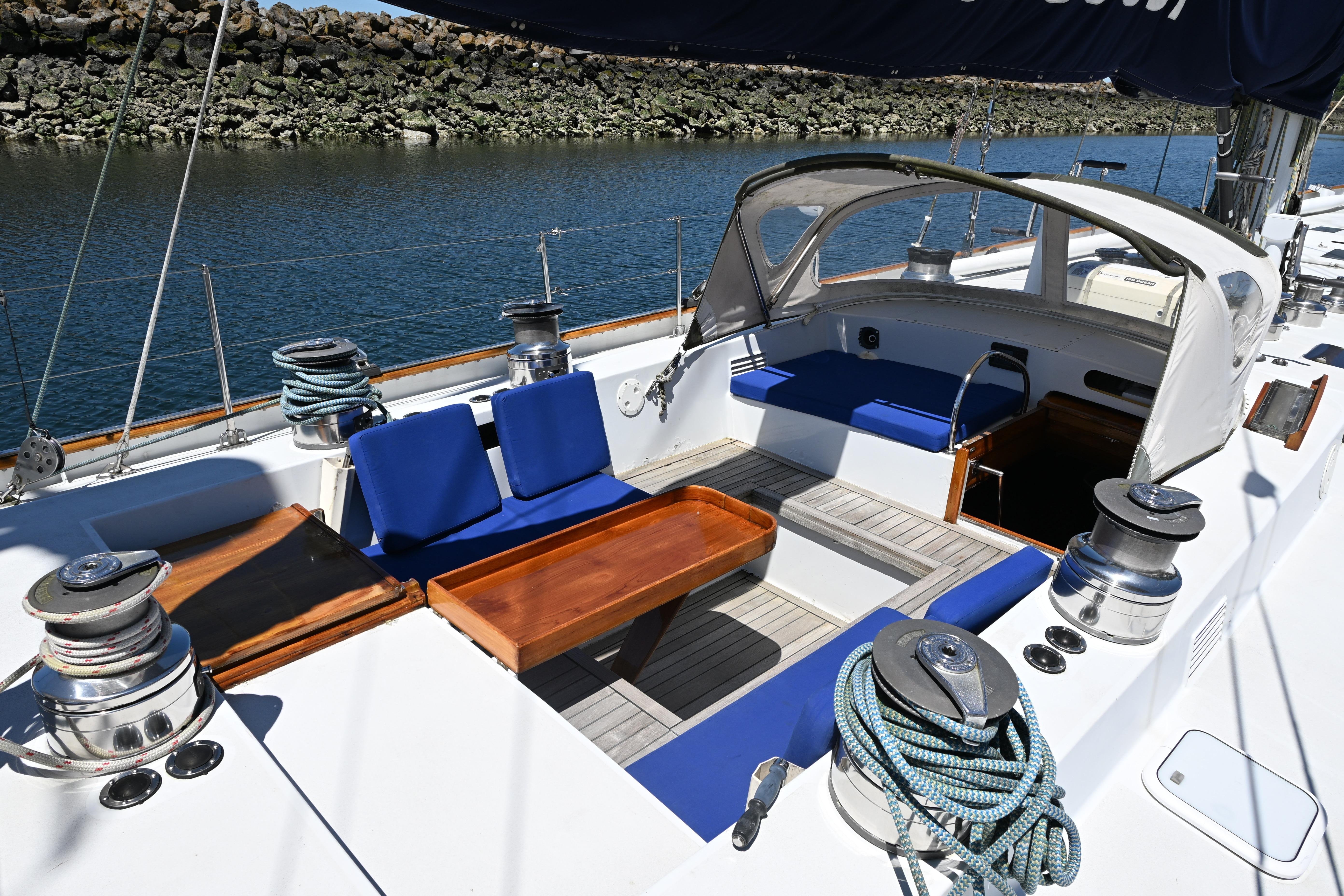 Cockpit of 1968 Abeking & Rasmussen Tripp 74 yacht with blue seating and wooden table.
