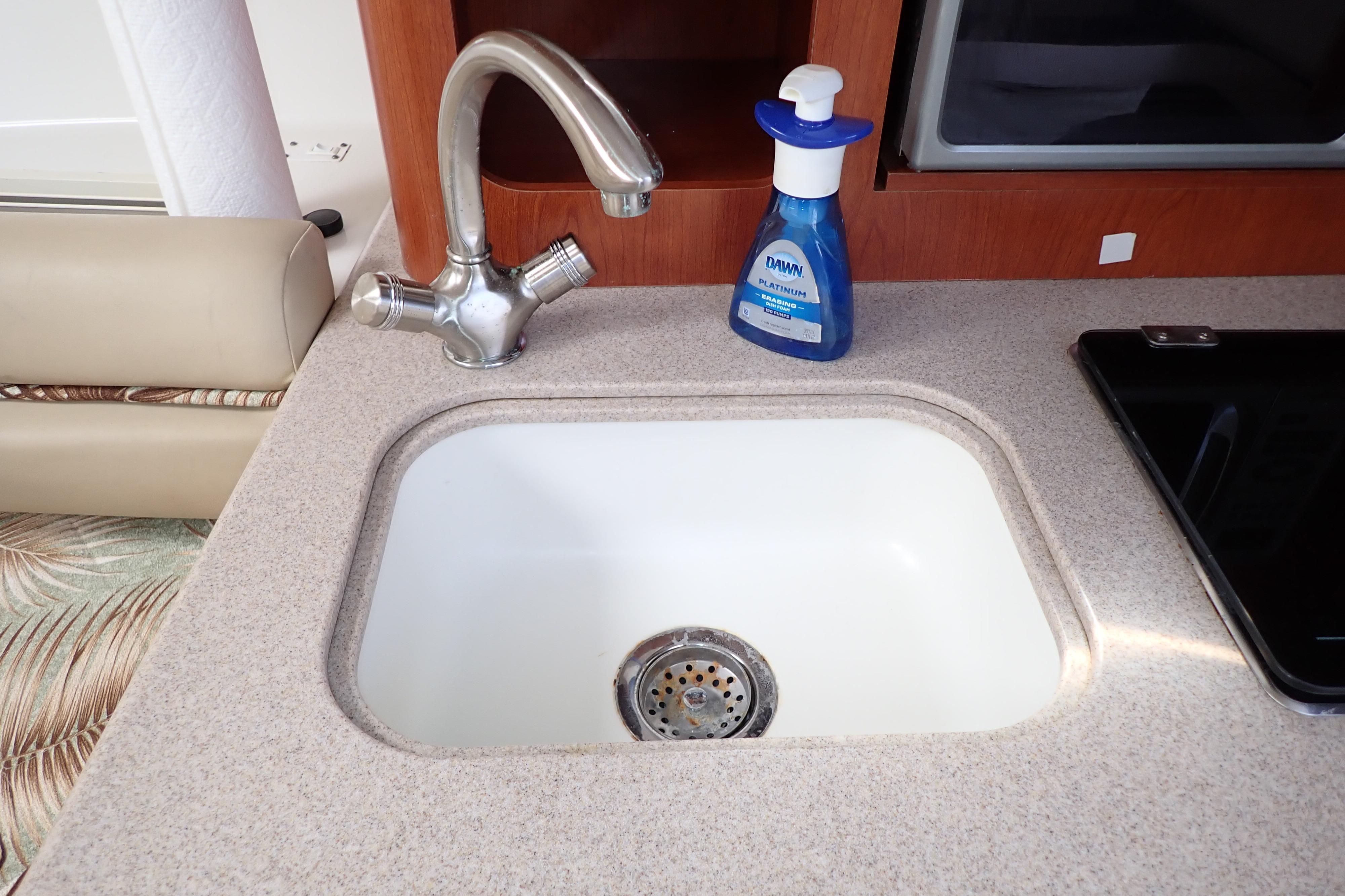 Kitchen sink area in 2014 Pro-Line 32 Express boat with faucet and soap bottle.