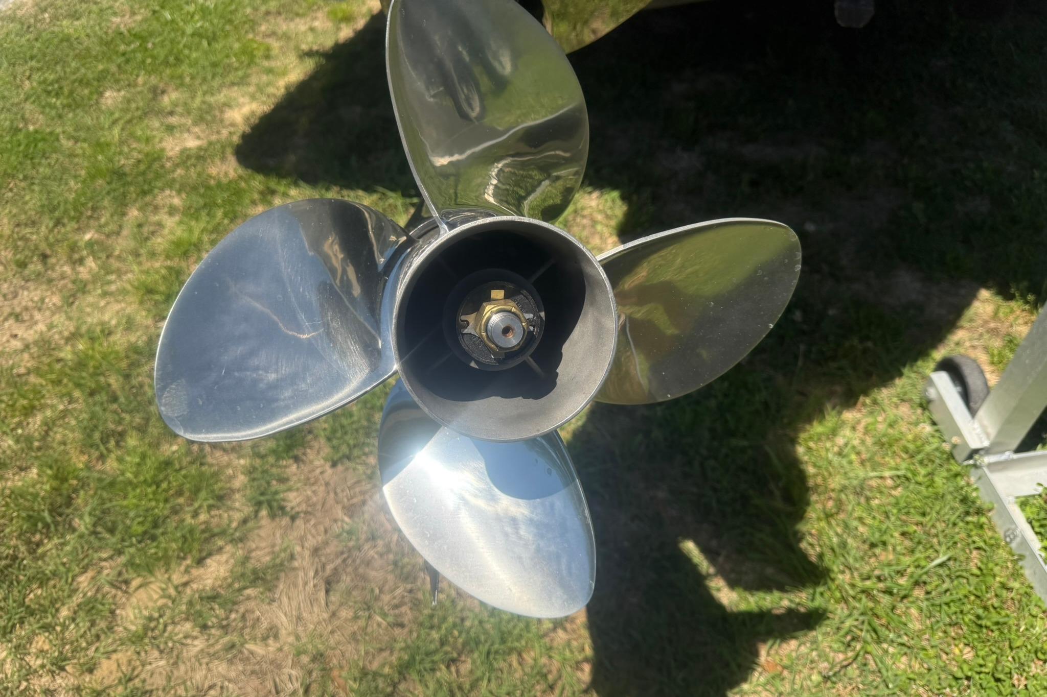 Shiny propeller of a 2021 Scout 215 Dorado boat on grass.