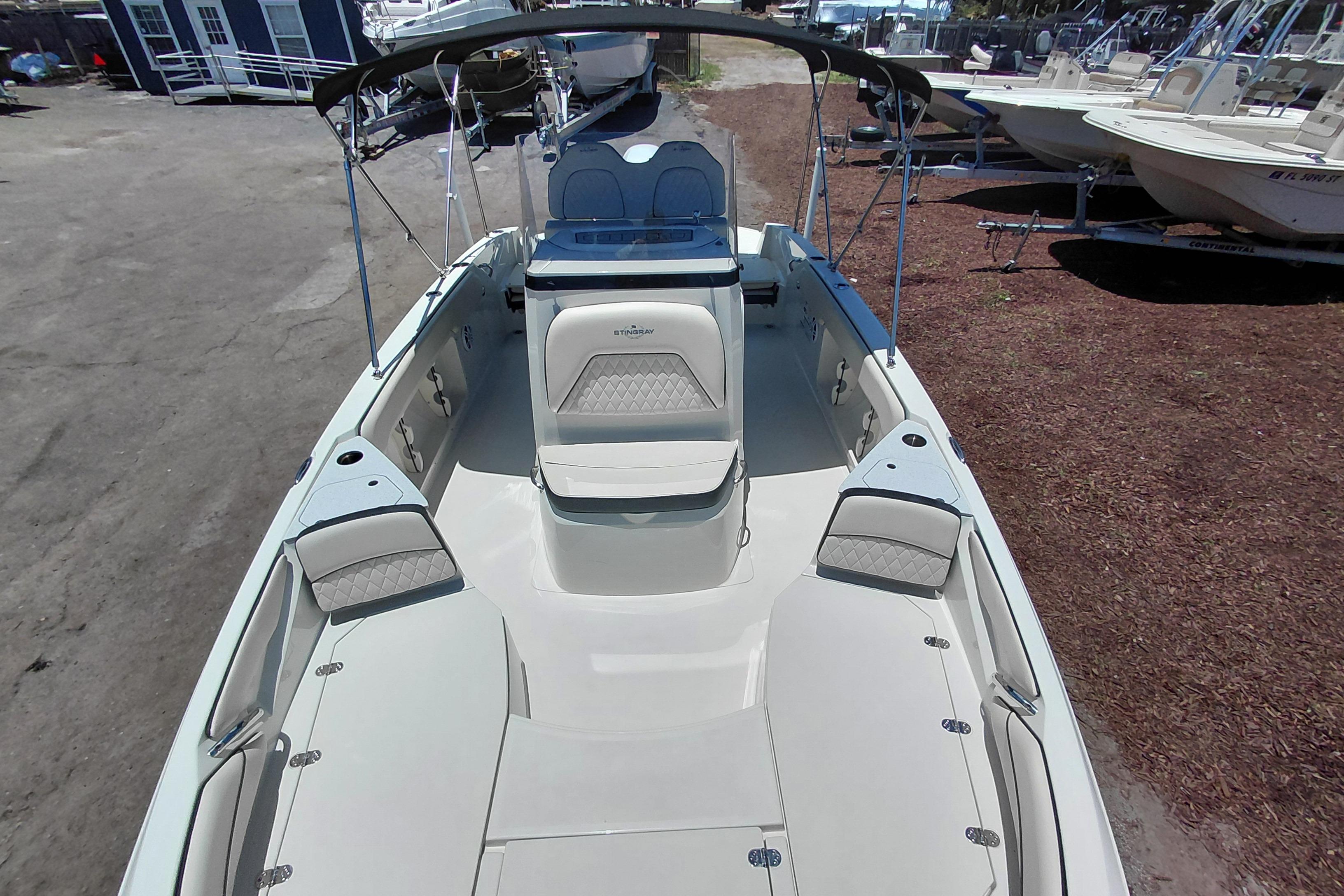 2023 Stingray 206 CC boat interior with seating and canopy, parked outdoors.