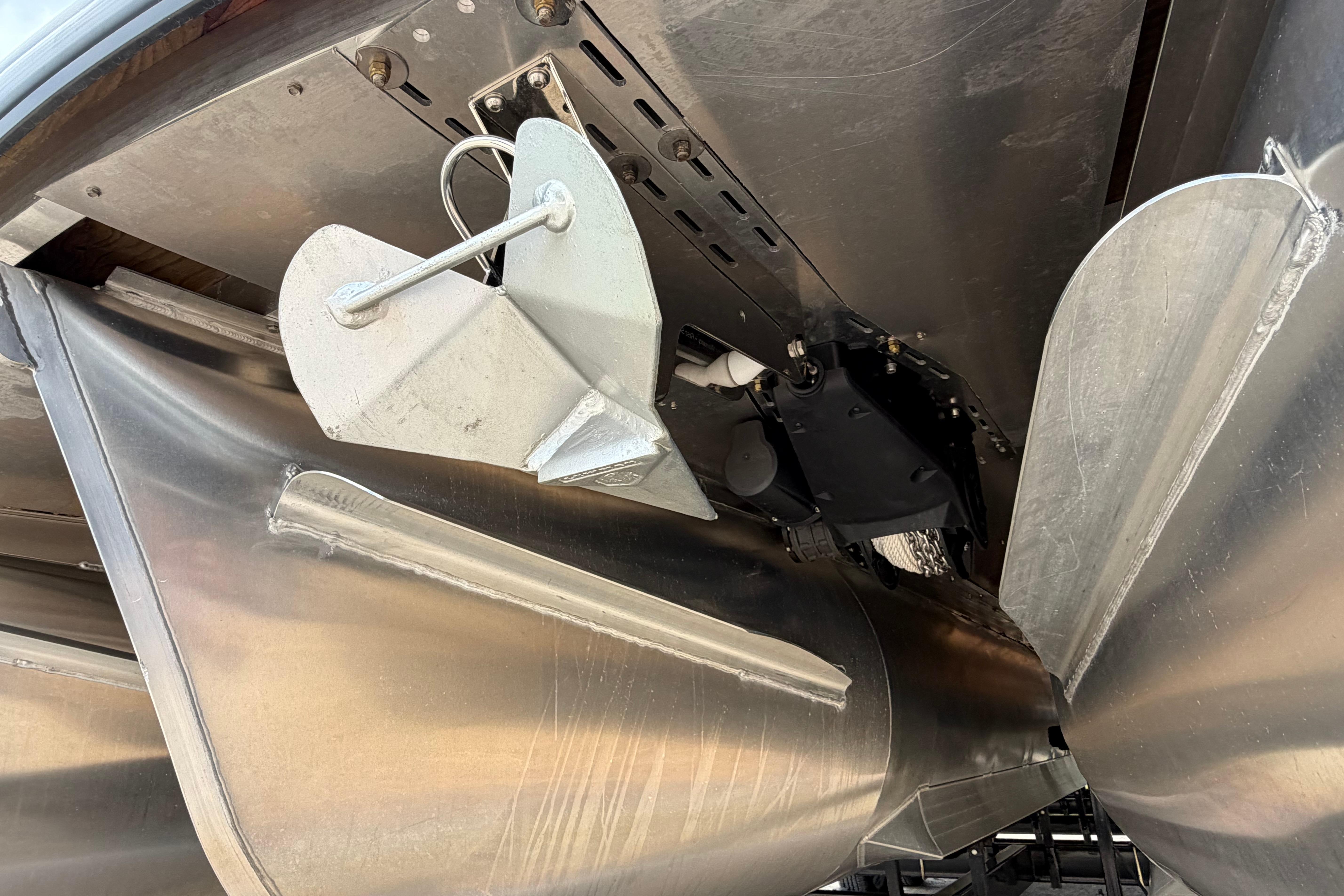 Underneath view of 2023 Godfrey Sanpan 2700 ULW Twin pontoon boat with anchor and metal structure.