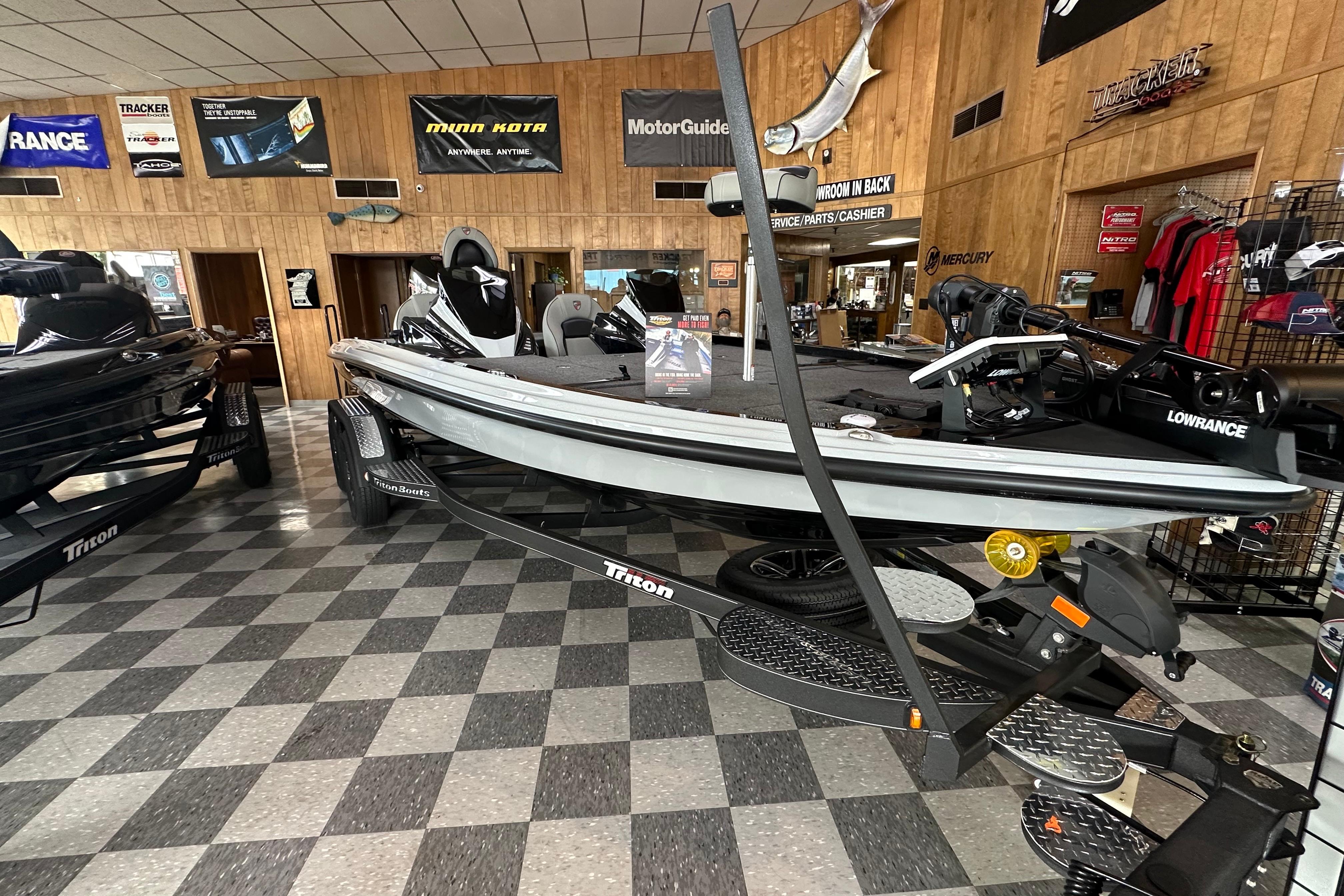 2024 Triton 20XP Patriot boat displayed in showroom with checkered flooring.