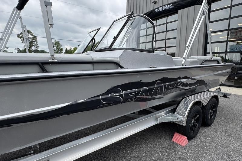 2025 SeaArk Super Lounge Easy boat on trailer, parked outside a building.
