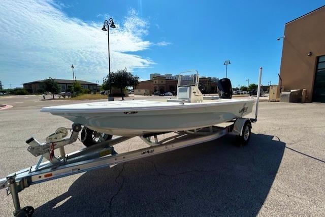 2026 Mako 18 Pro Skiff boat on trailer in sunny parking lot.