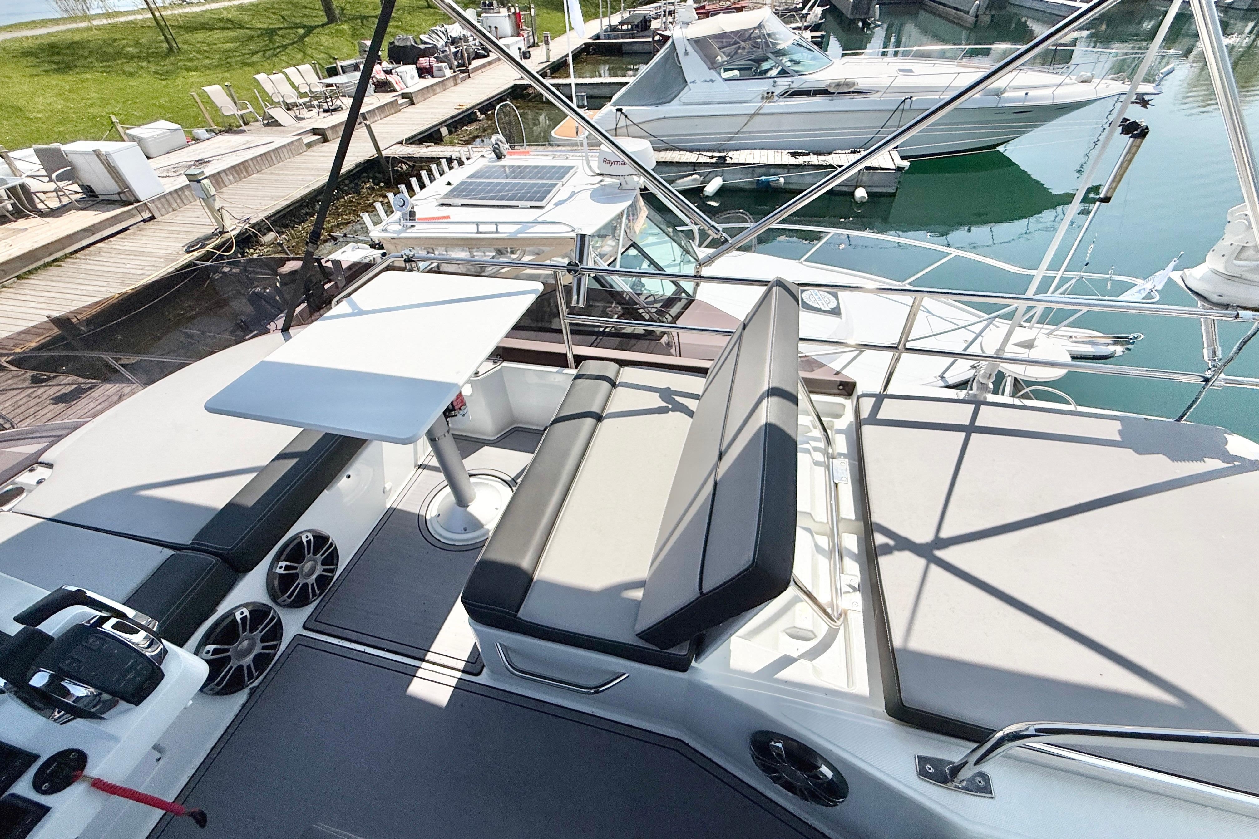 Flybridge view of 2022 Jeanneau NC 1095 Fly, featuring seating and table.