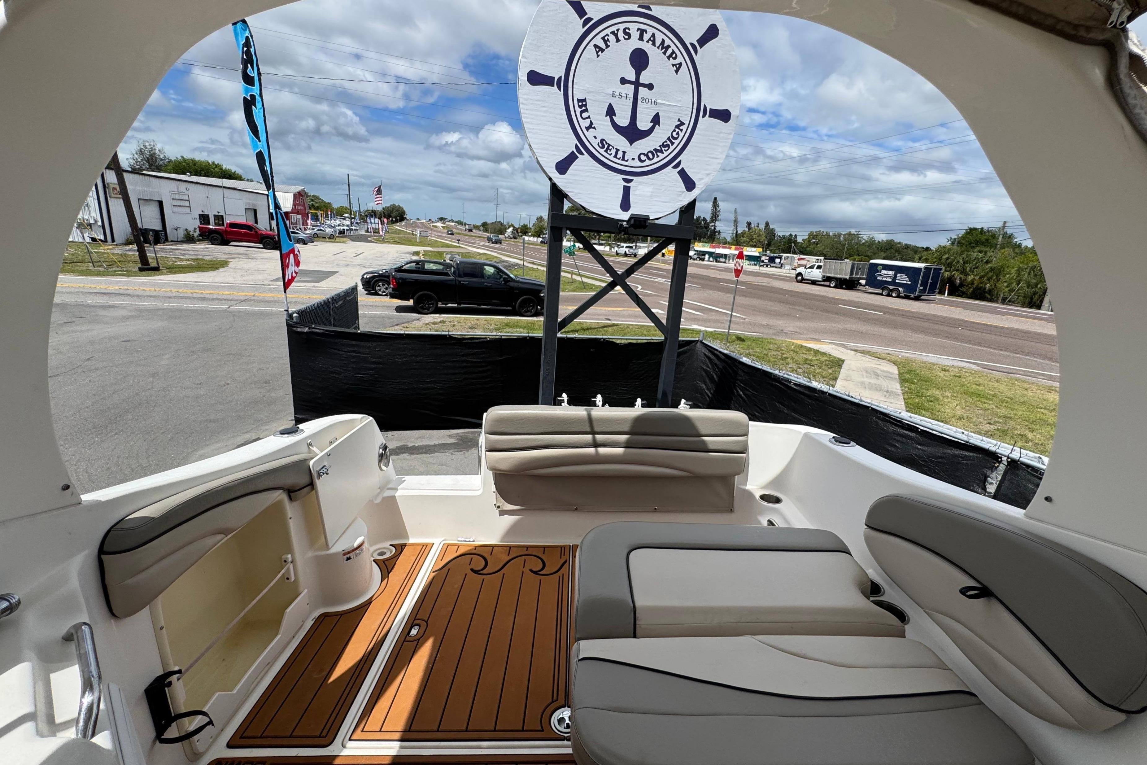 2008 Larson Cabrio 260 boat interior with seating, wood flooring, and outdoor view.