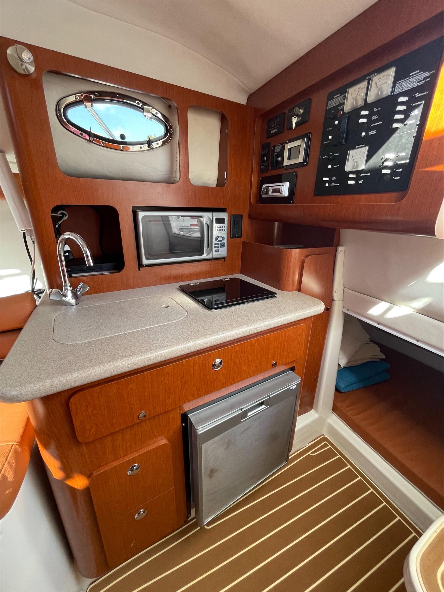 The galley of a 2006 Pro-Line 32 Express with a microwave and refrigerator.
