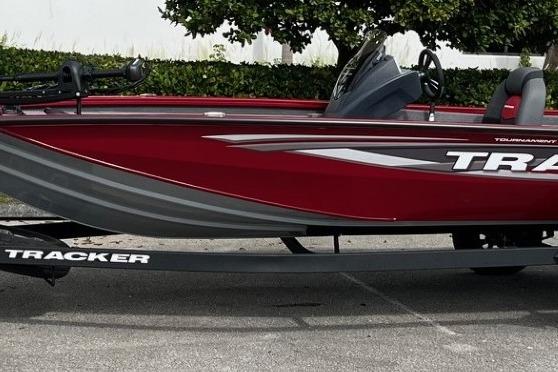 2025 Tracker Pro Team 195 Tournament Edition boat, red and gray design, parked on trailer.