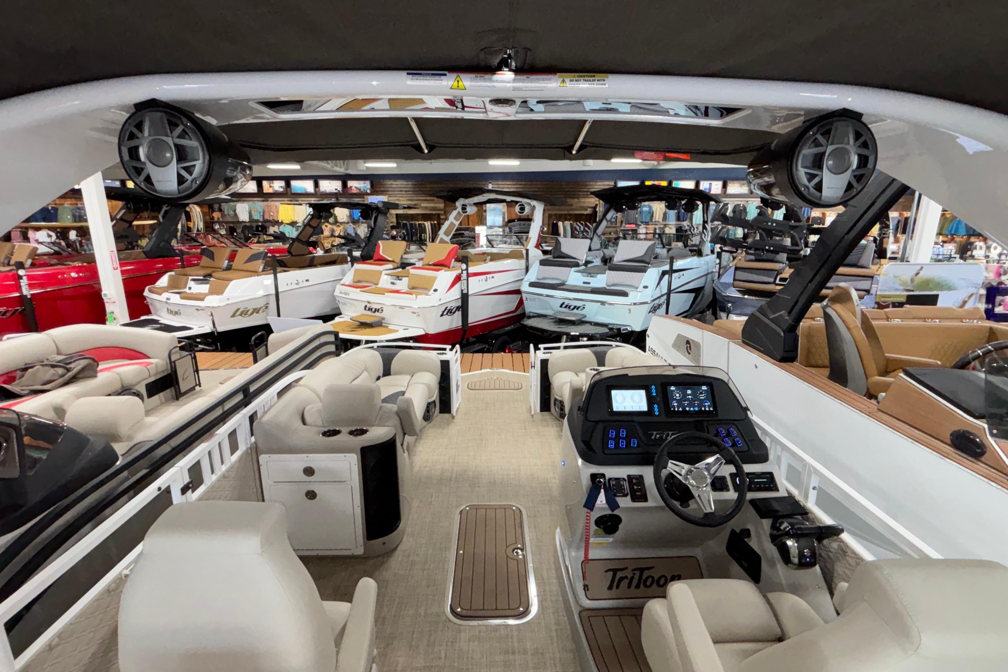 Interior view of a 2026 JC Sporttoon 26TT boat in a showroom.