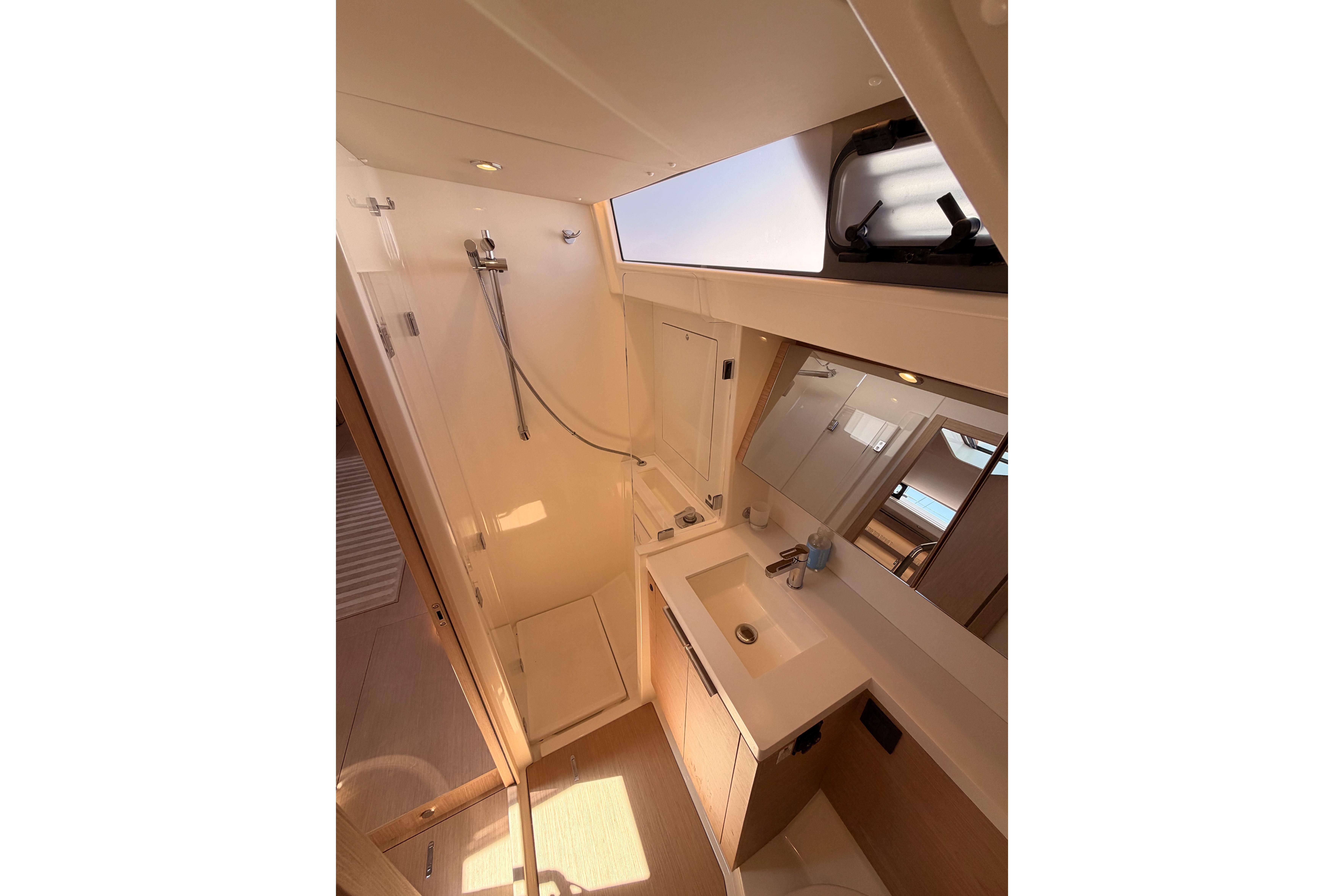 Luxurious bathroom in 2022 Beneteau Oceanis Yacht 54, featuring modern fixtures and ample natural light.