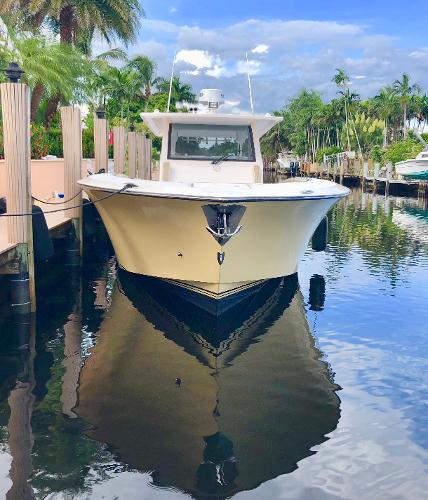 2019 Altima 38 Xcape boat docked in a serene, tropical marina setting.