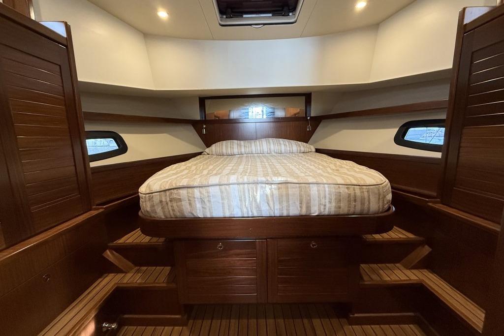 Luxurious cabin interior of 2012 Sasga Yachts Menorquin 42 with wooden finish and cozy bed.
