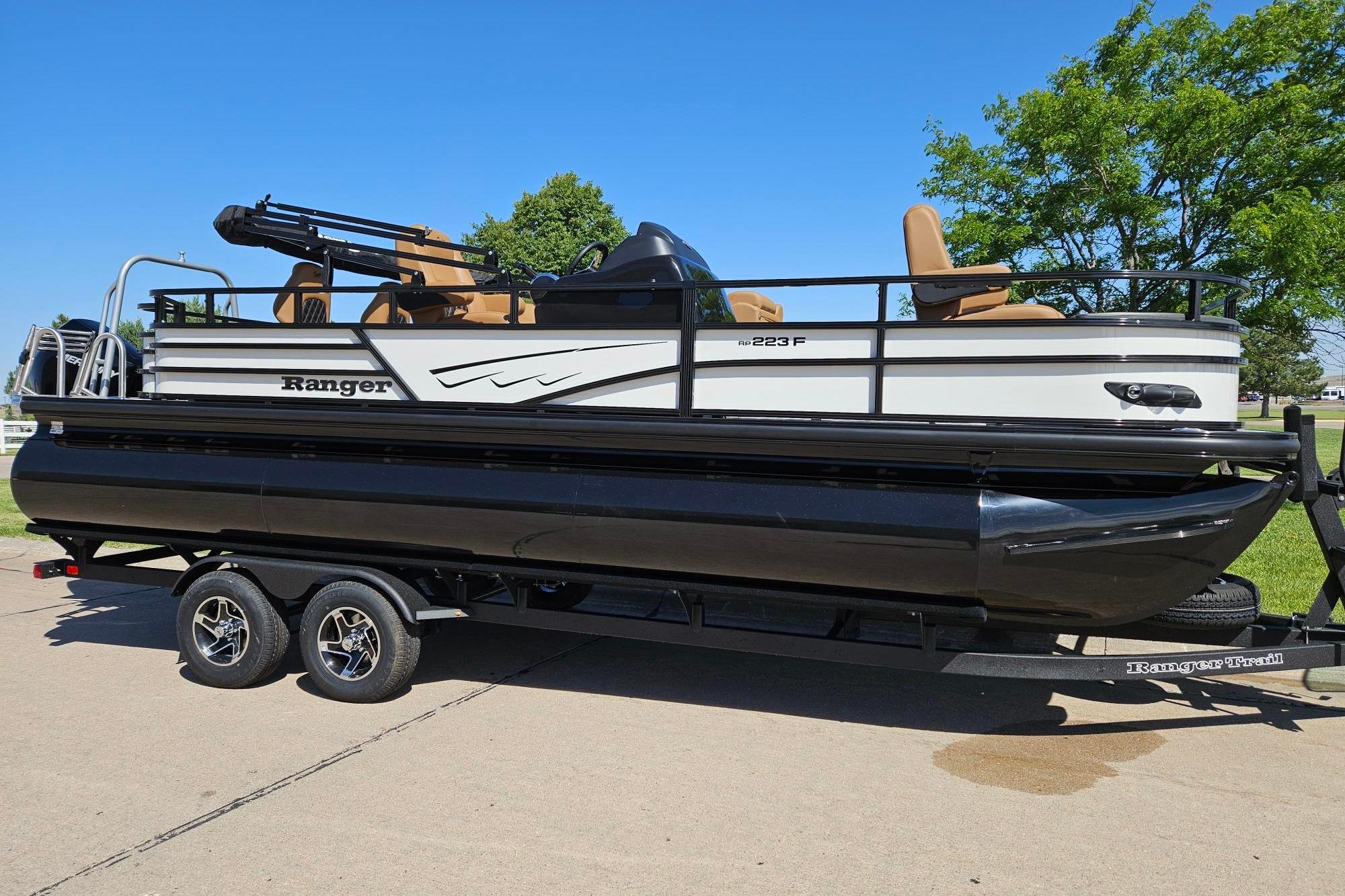 2026 Ranger 223F pontoon boat on trailer, parked outdoors under clear blue sky.