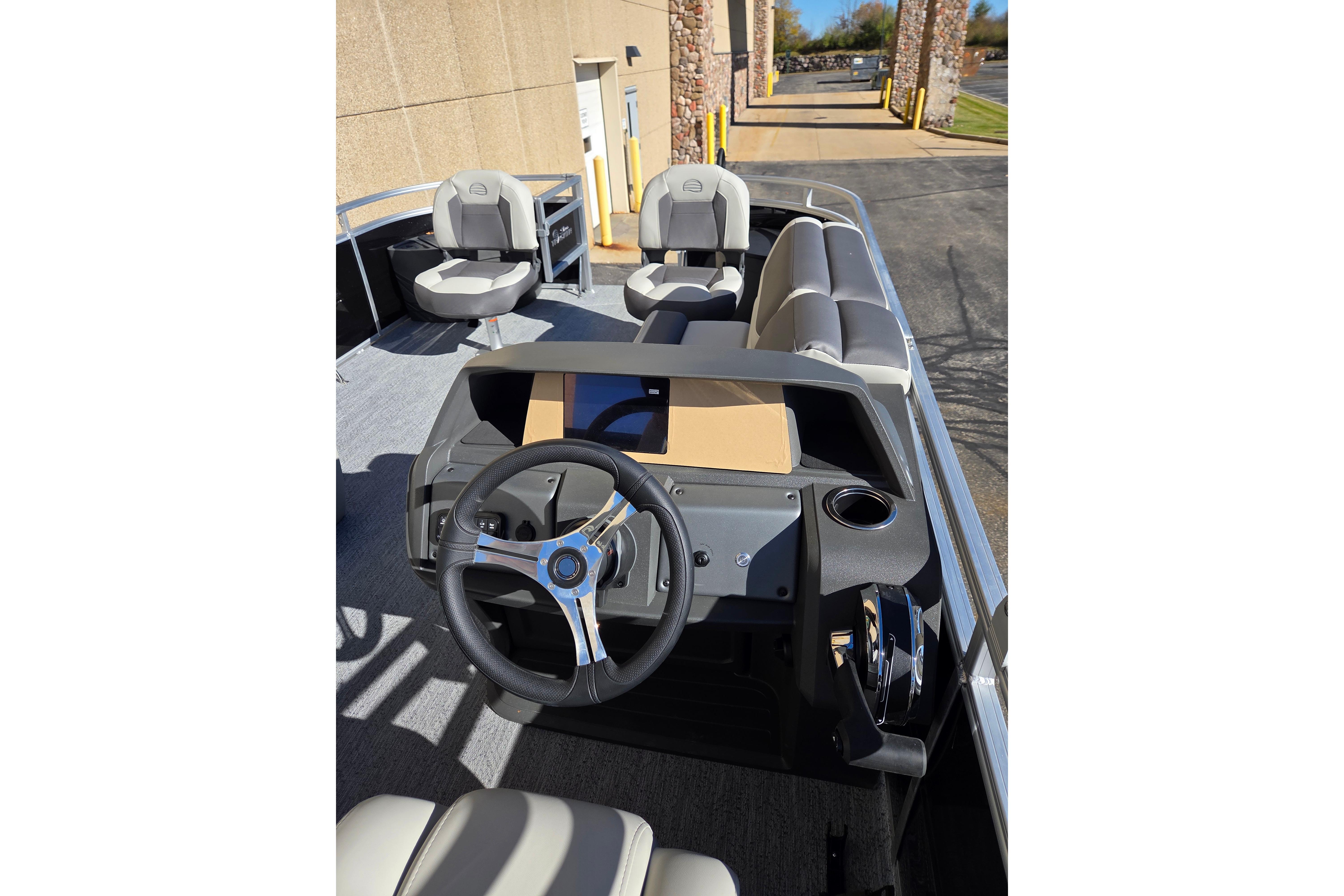 2026 Sun Tracker Fishin' Barge 20 DLX interior with steering wheel and seating.