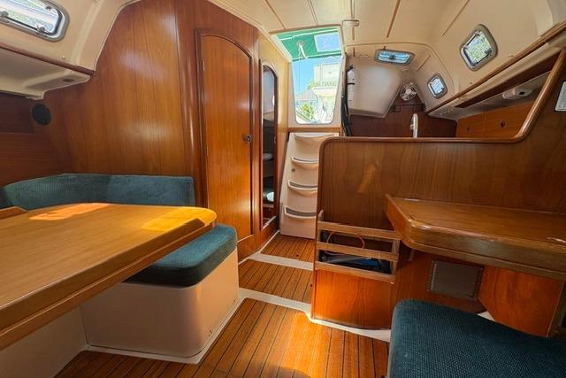 Interior of 2000 Beneteau Oceanis 321 sailboat with wooden furnishings and seating area.