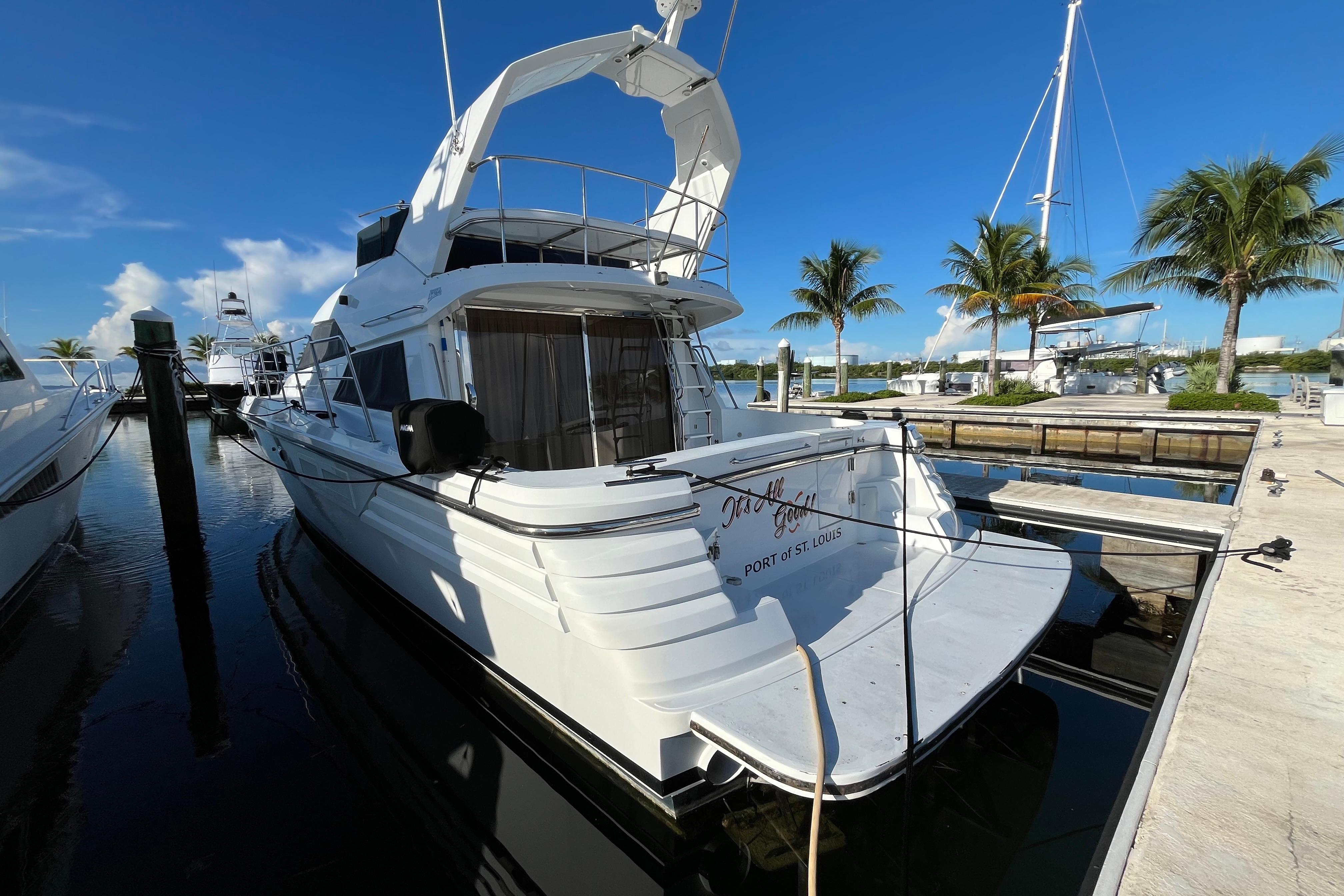 2001 Jefferson International 5300 yacht docked at marina with palm trees and clear blue sky.