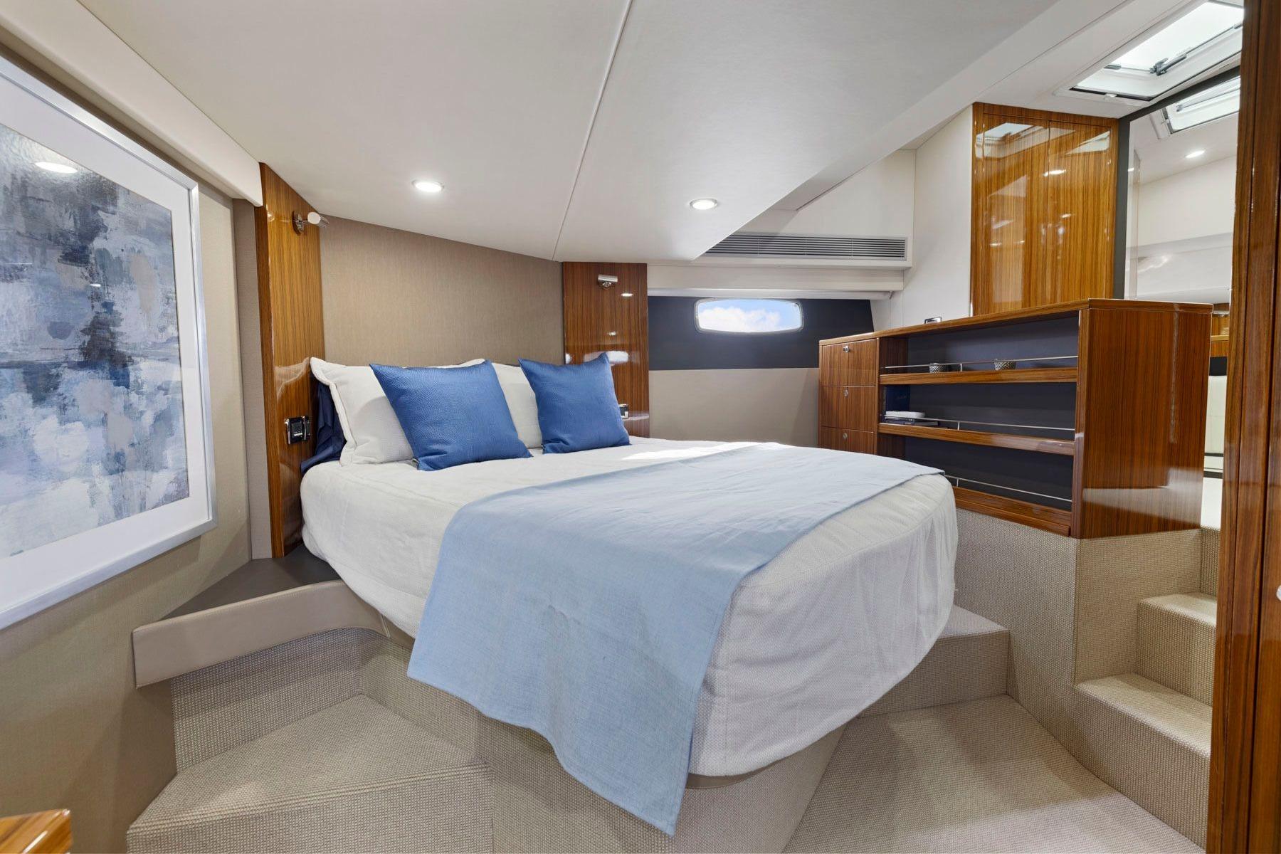 Luxurious cabin interior of 2014 Maritimo M50 yacht with elegant bedding and wood finishes.