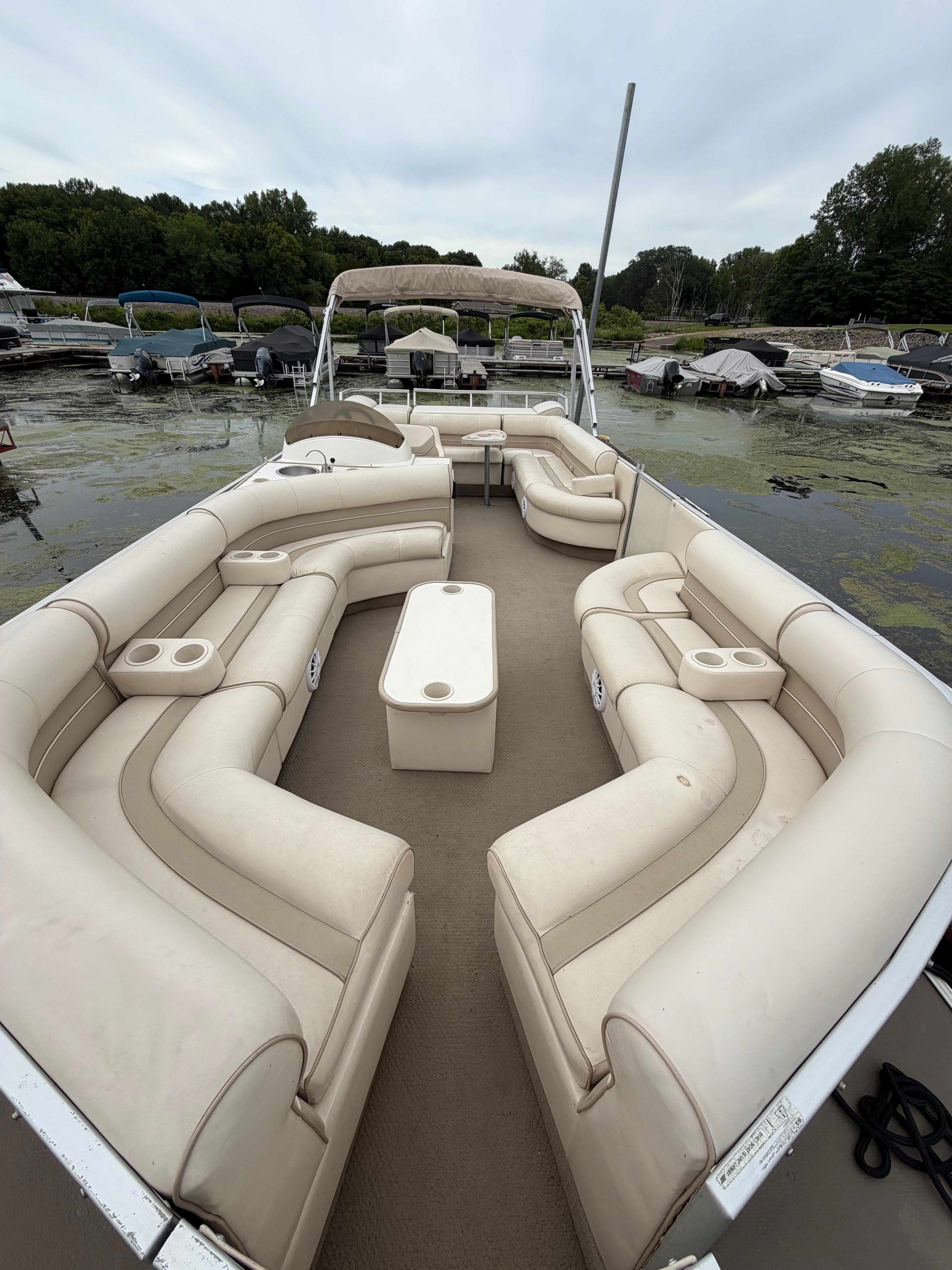 Crest Grand Caribbean 2000 with beige cushioned seating and table, on a calm lake.