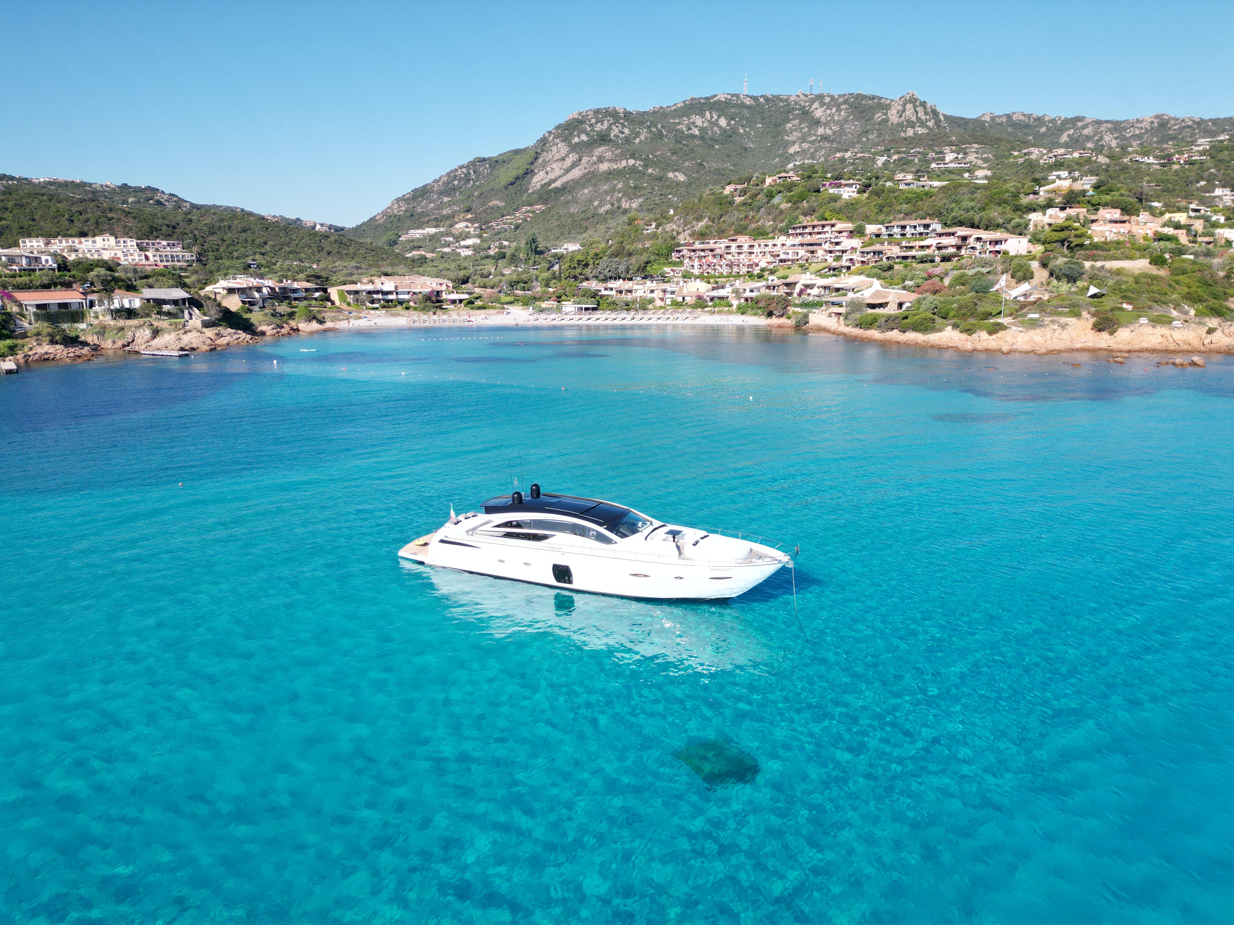 Luxury Pershing 80 yacht in clear blue waters near scenic coastline, 2008 model.