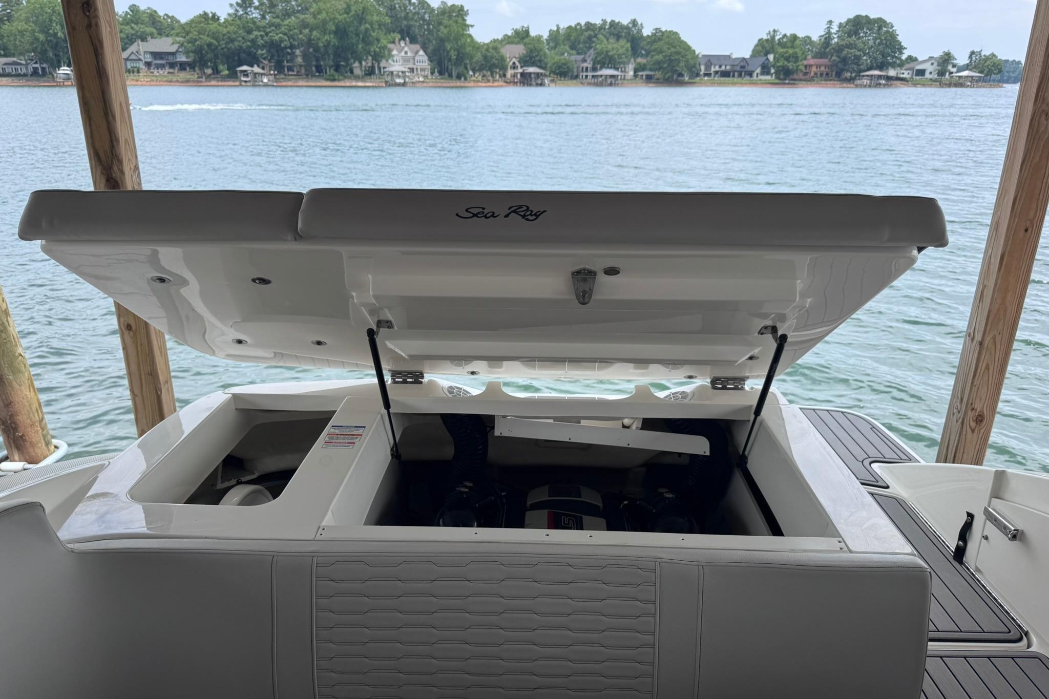 2021 Sea Ray SPX 230 boat with open engine compartment by a scenic lake.