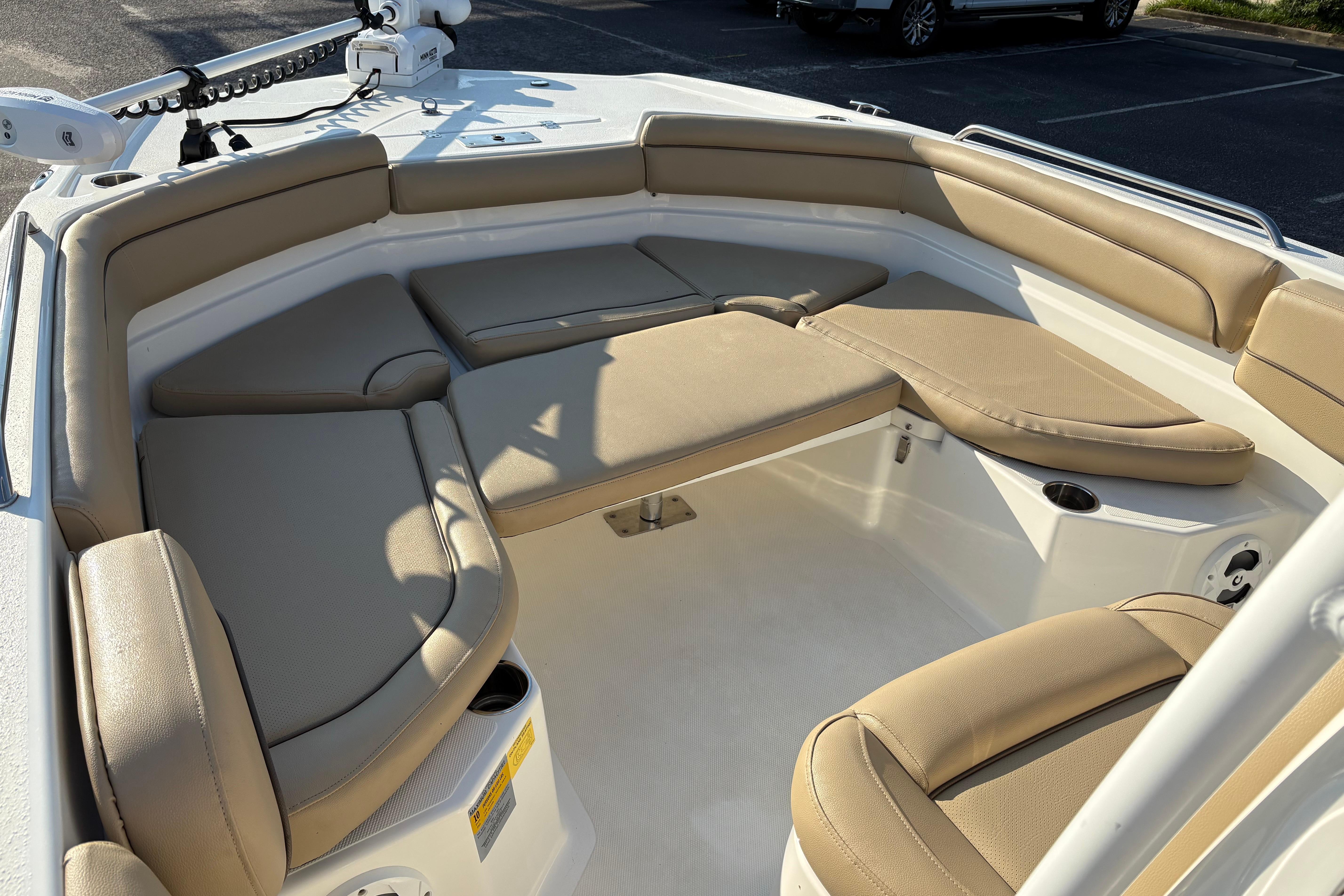 2019 NauticStar 231 Hybrid boat interior with tan cushioned seating and cup holders.