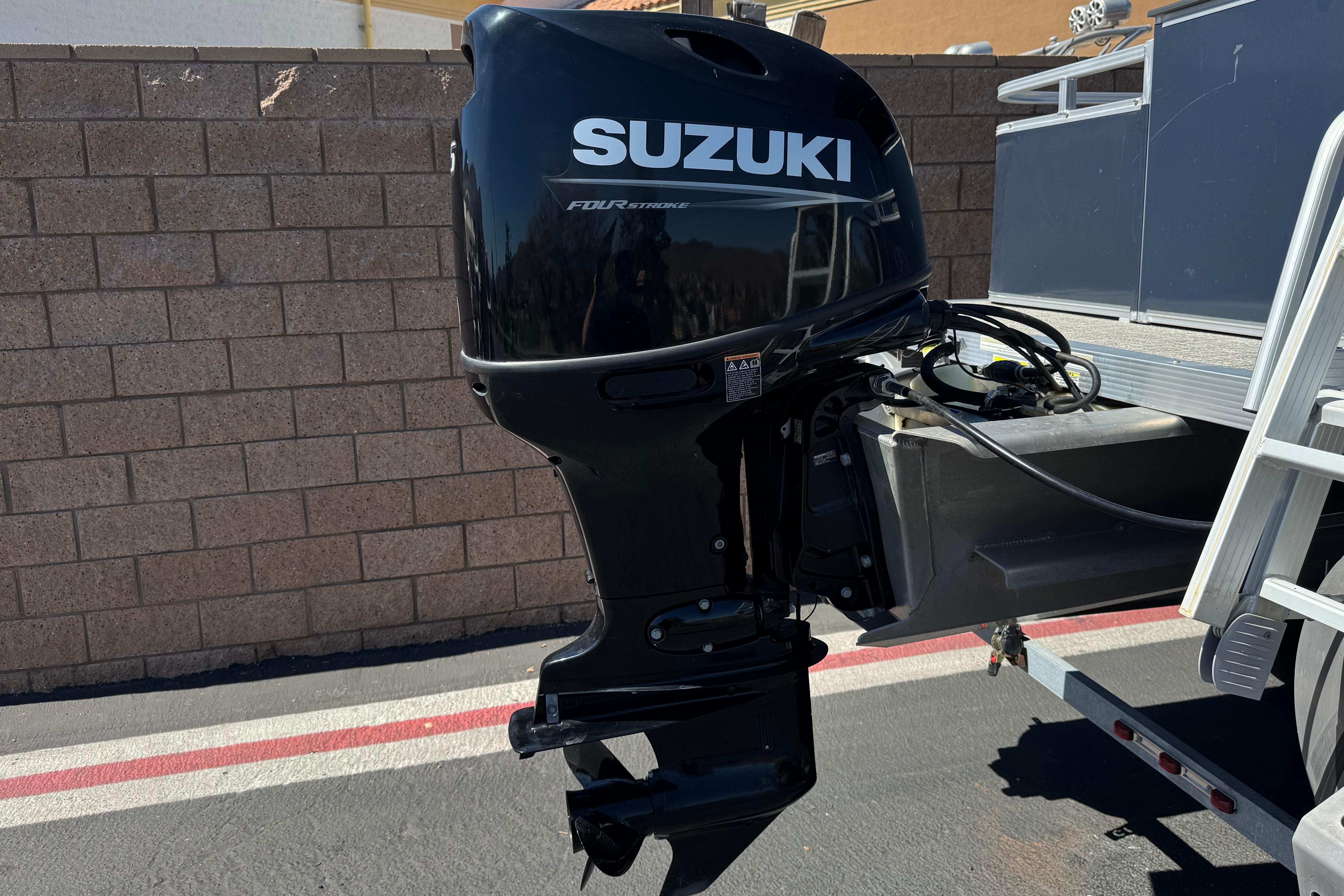 2023 Avalon Venture Fish N Cruise boat with Suzuki outboard motor, parked on a trailer.
