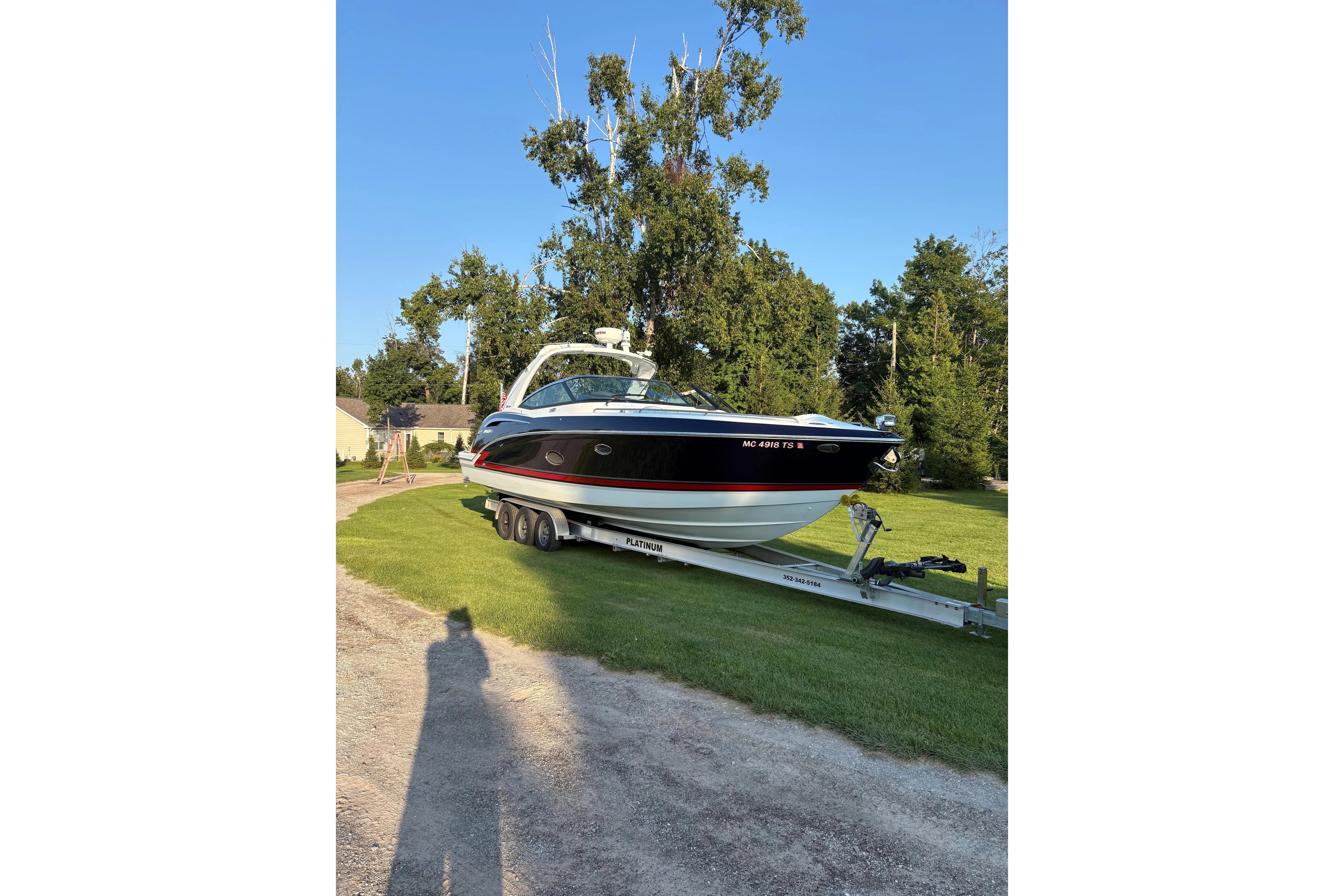 2015 Formula 350 Crossover Bowrider on trailer, parked on grass, sunny day.