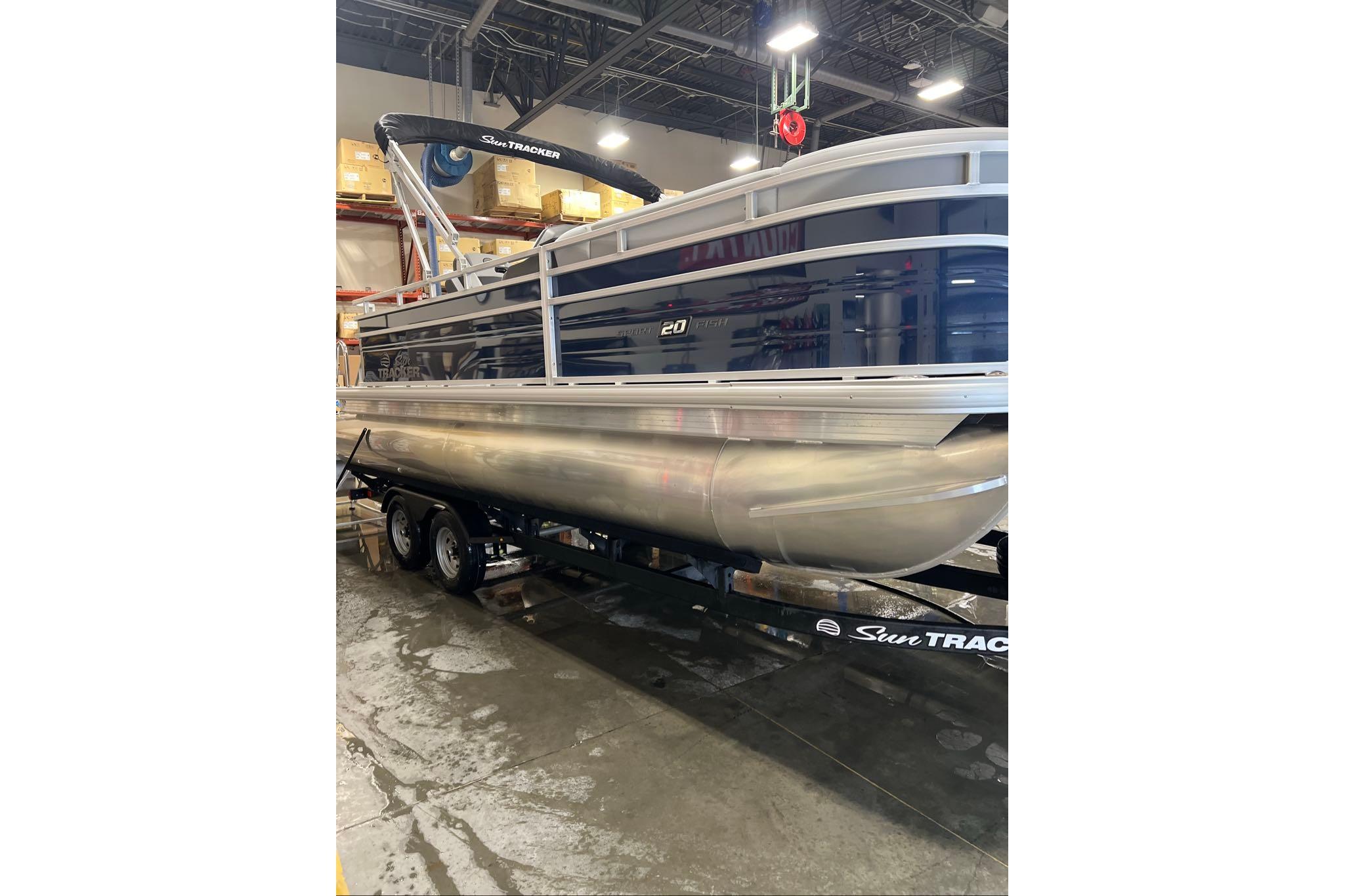 2026 Sun Tracker SportFish 20 DLX pontoon boat in a warehouse setting.