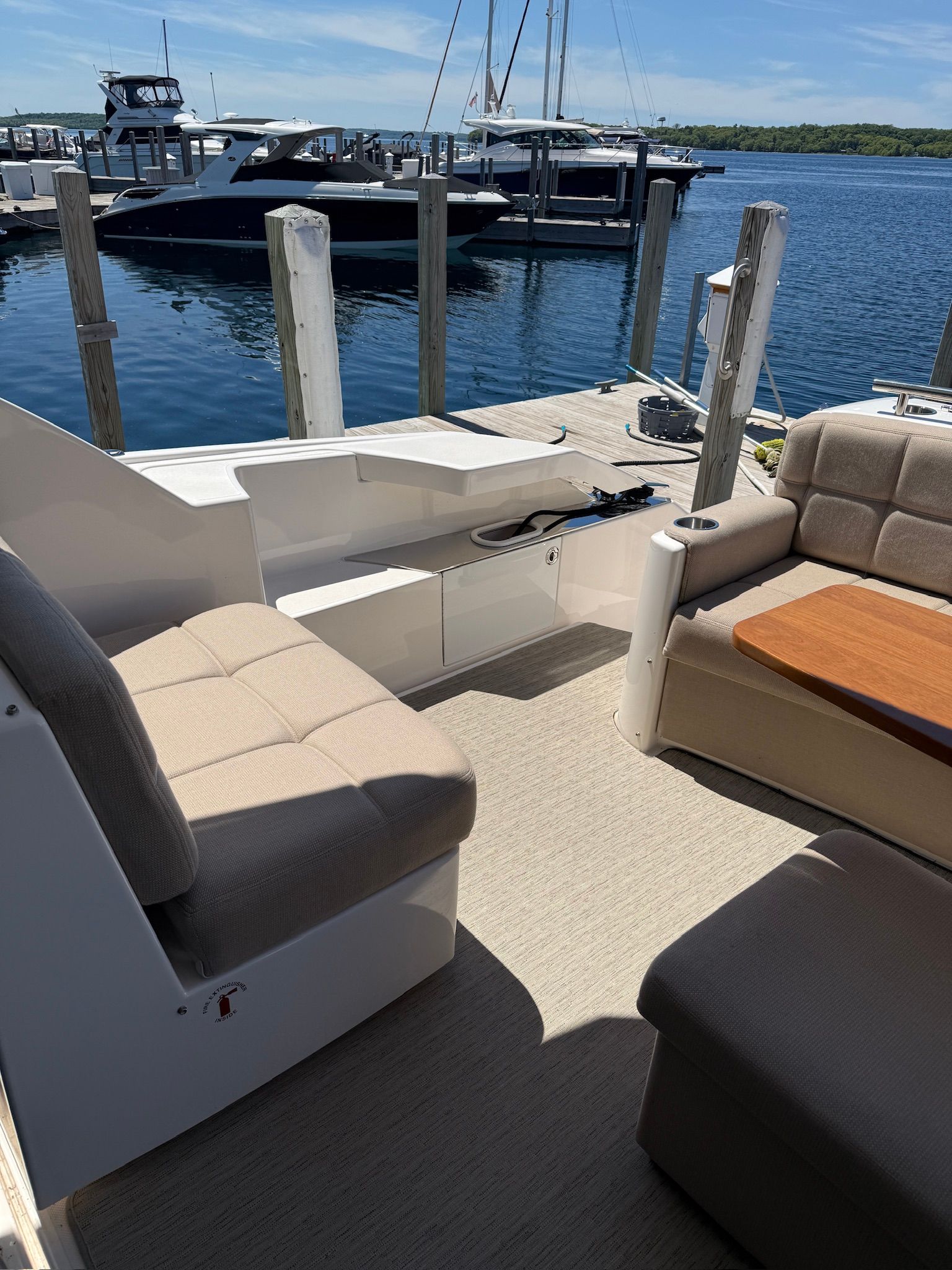 The image shows the cockpit of a 2017 Tiara Yachts C44 Coupe docked at a pier.