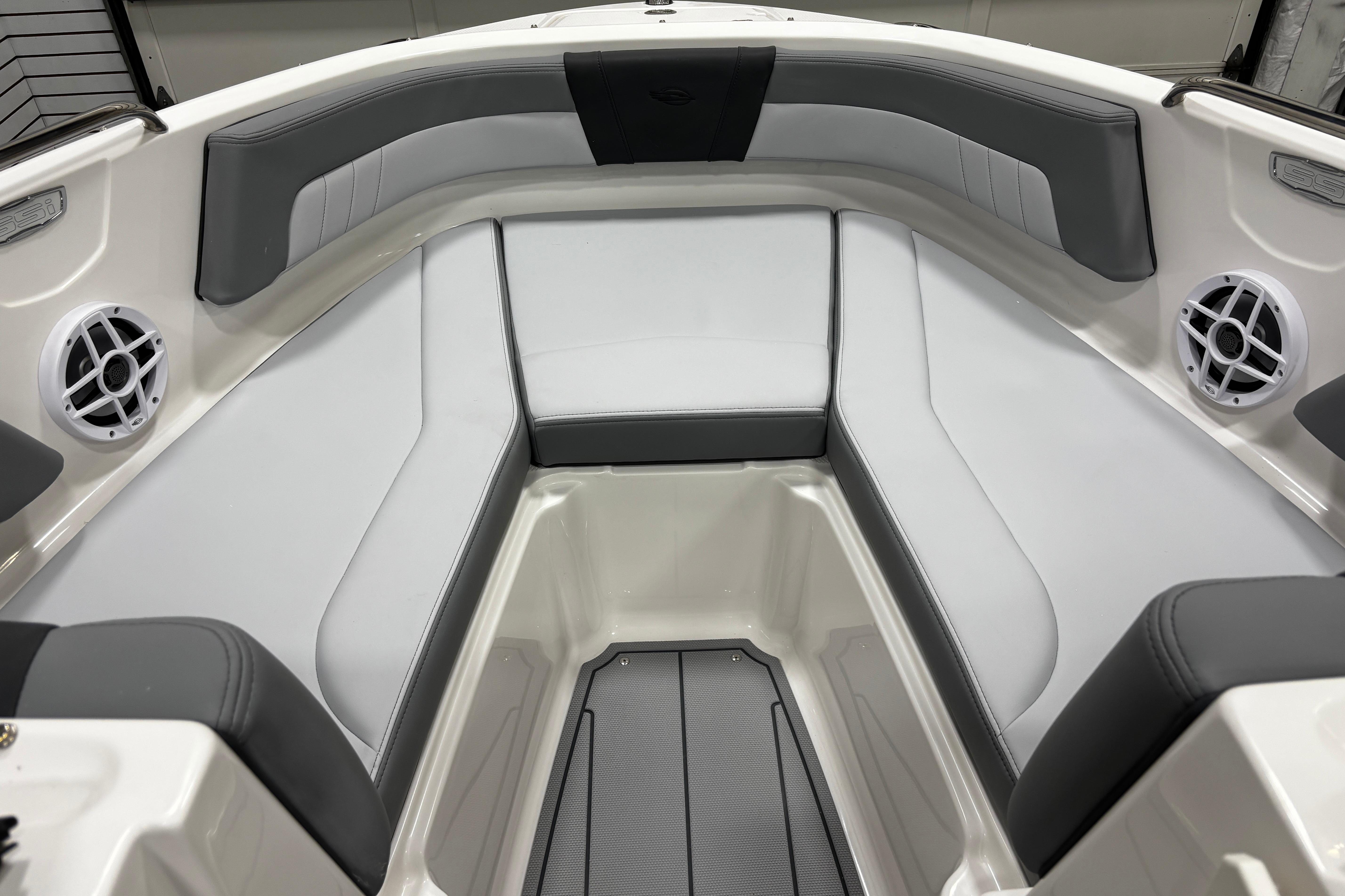 2026 Chaparral 21 SSi boat interior with gray and white seating and built-in speakers.