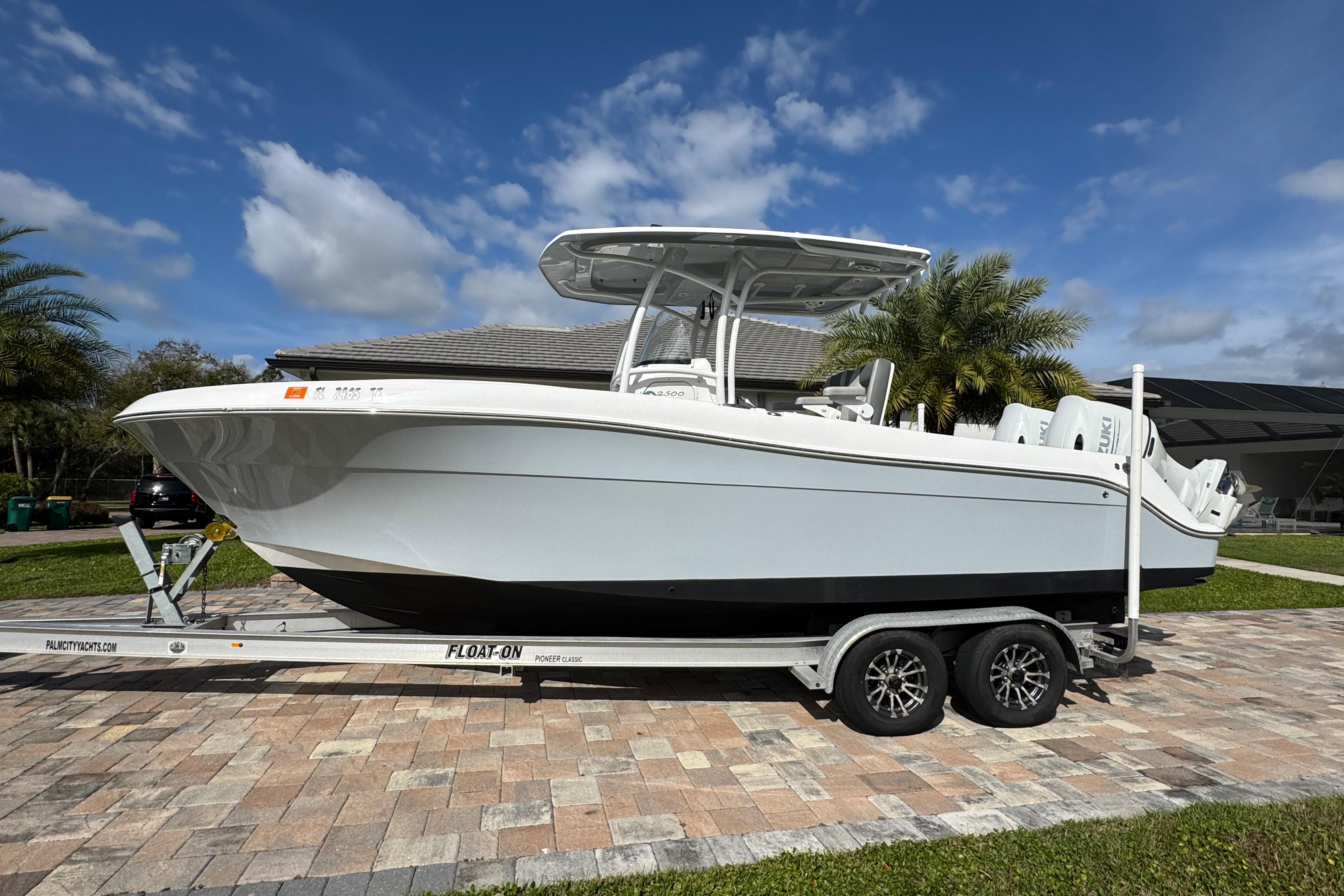 2022 Aquasport 2500 Center Console boat on trailer, parked on a paved driveway.