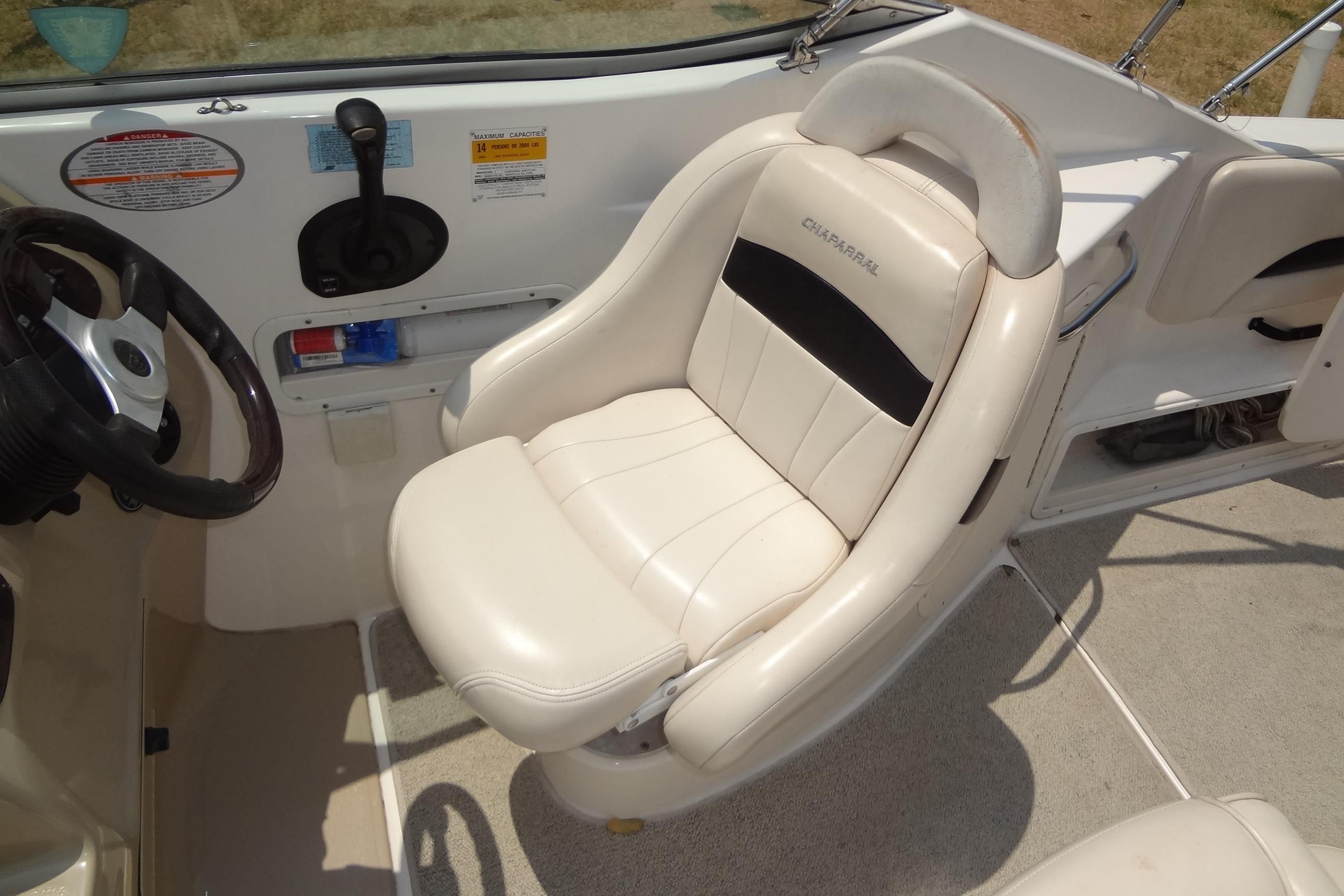 2000 Chaparral Signature 260 boat interior with steering wheel and white captain's chair.