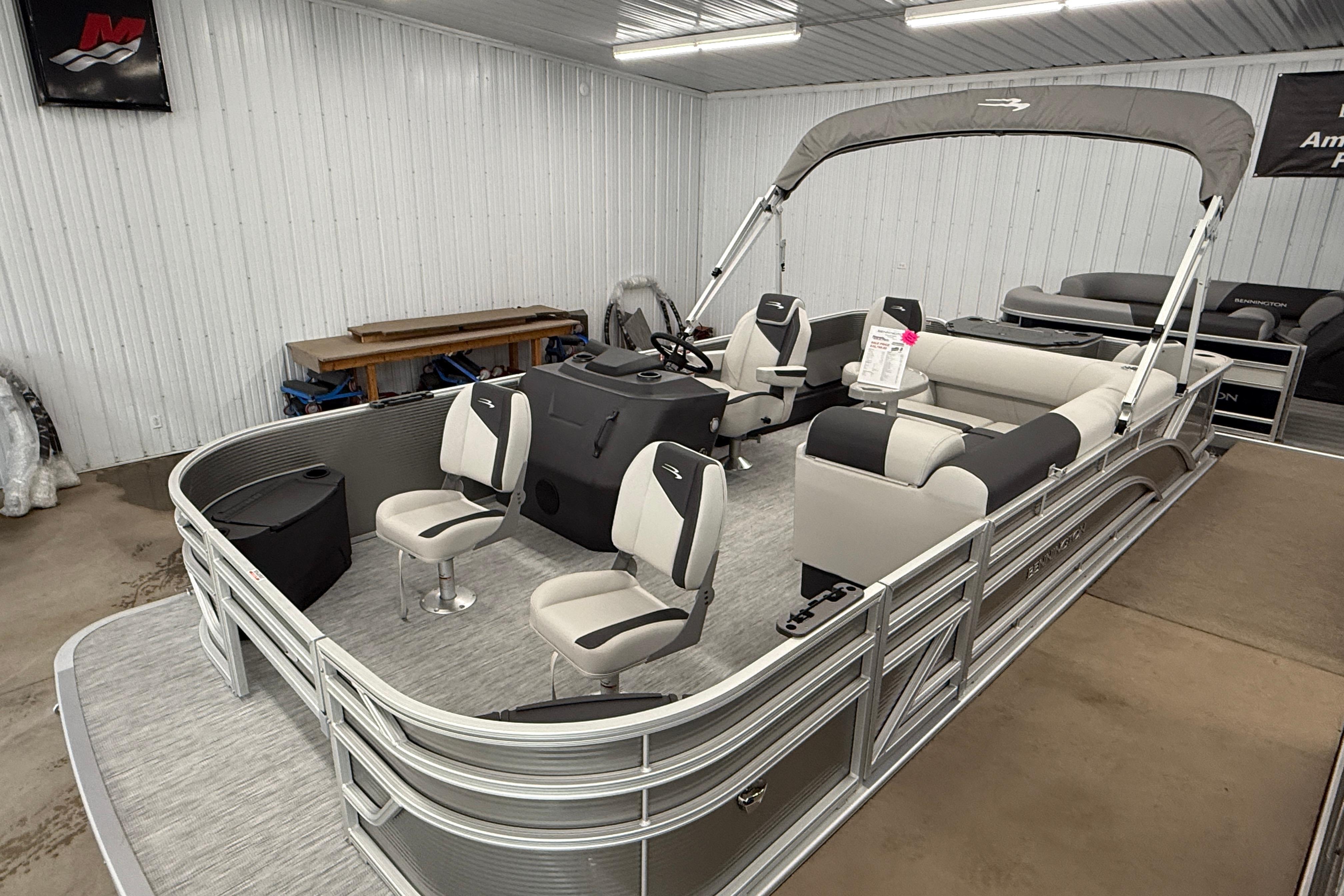 2026 Bennington 20 SF pontoon boat with seating and canopy in a showroom.