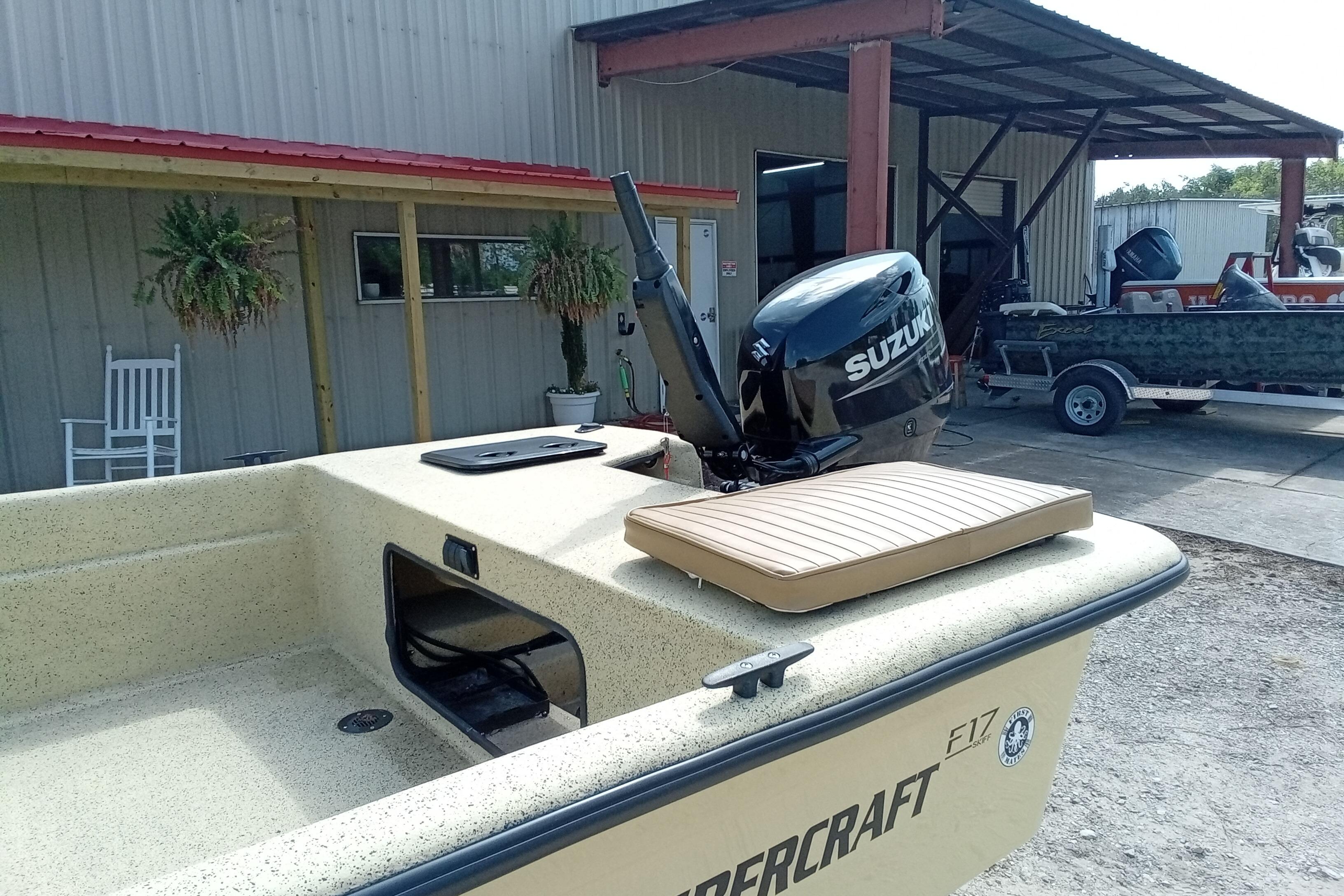 Fibercraft F17 boat with Suzuki motor, parked near a metal building, 2025 model.