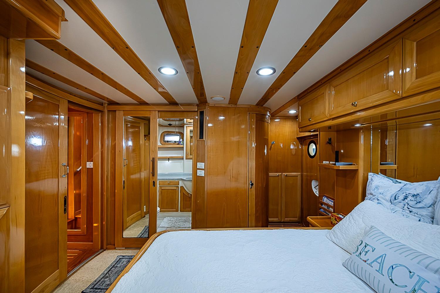 Luxurious 2003 Magna Marine Nova Scotia 47 yacht cabin with elegant wood finish and cozy bedding.