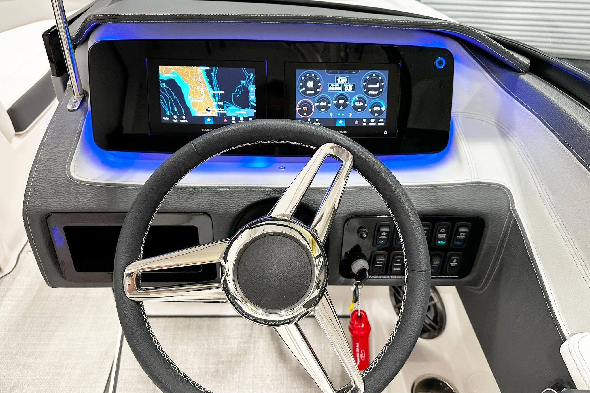 Steering wheel and digital dashboard of 2025 Regal LS2 boat, featuring navigation displays.