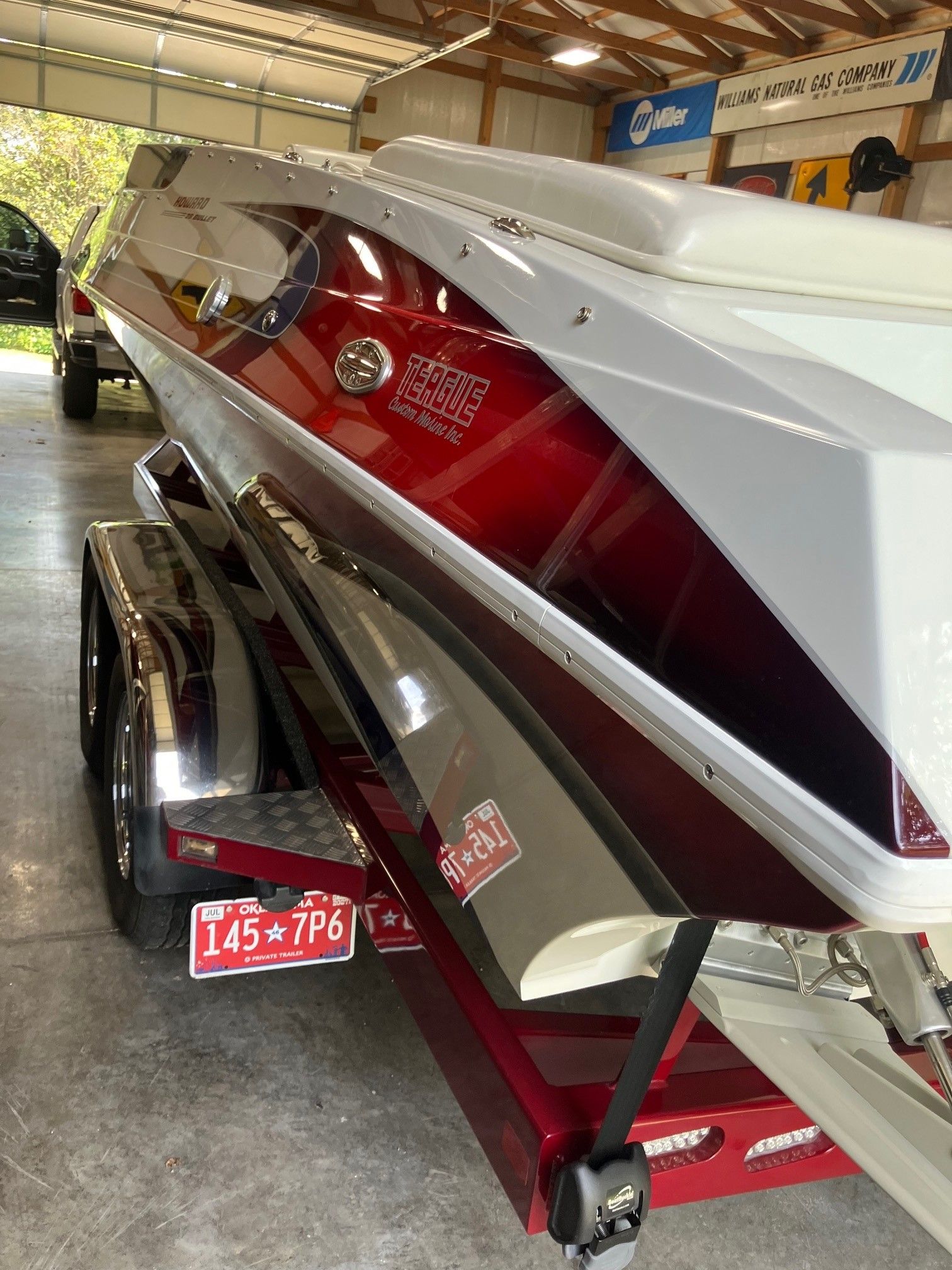 A 2003 Howard Bullet boat on a trailer in a garage.