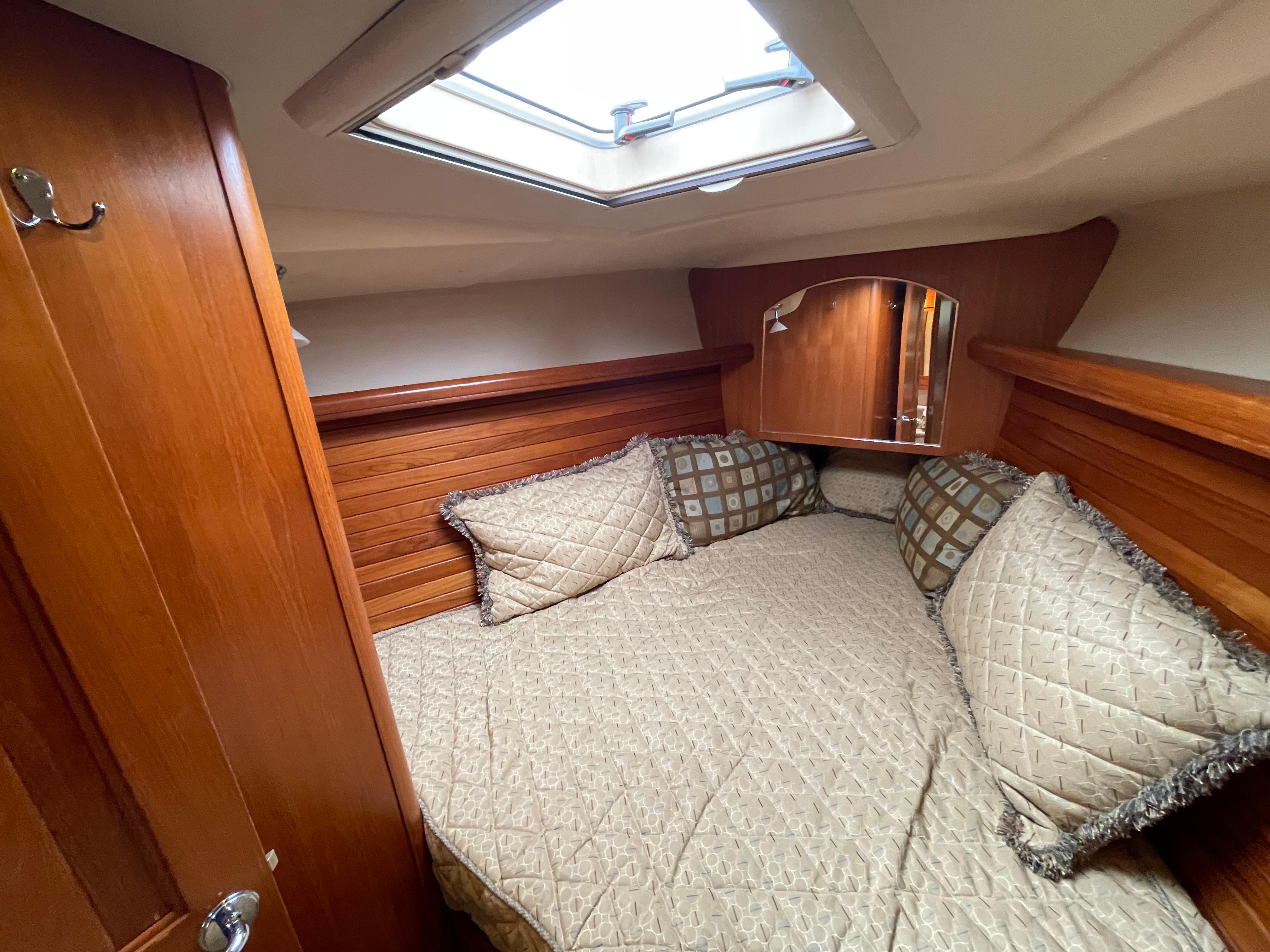 Cozy cabin interior of 2006 Hunter 45cc sailboat with skylight and plush bedding.